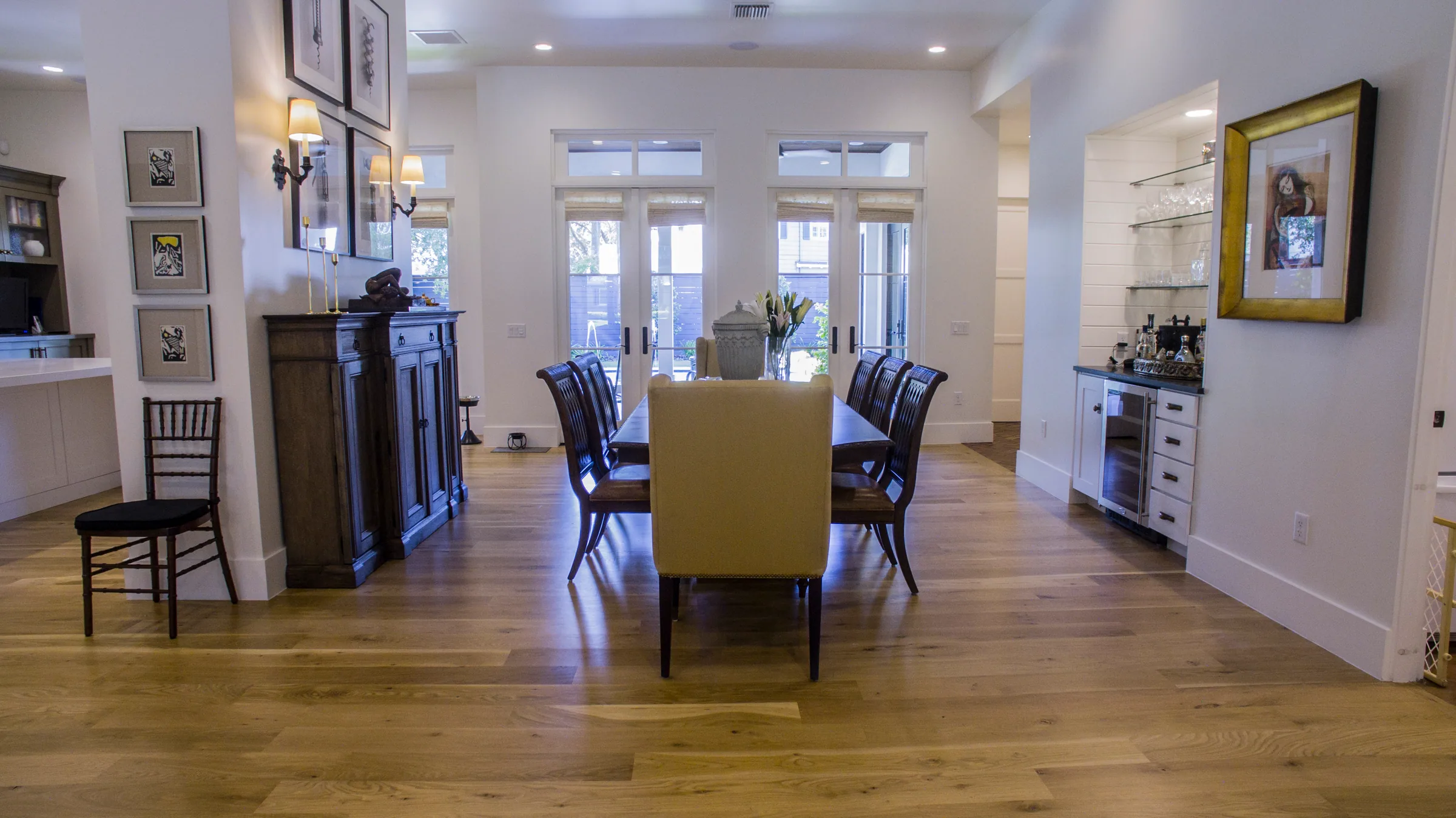 Dining room with paired glazed doors, transom windows and a built-in display alcove with glass shelves and white cabinets.