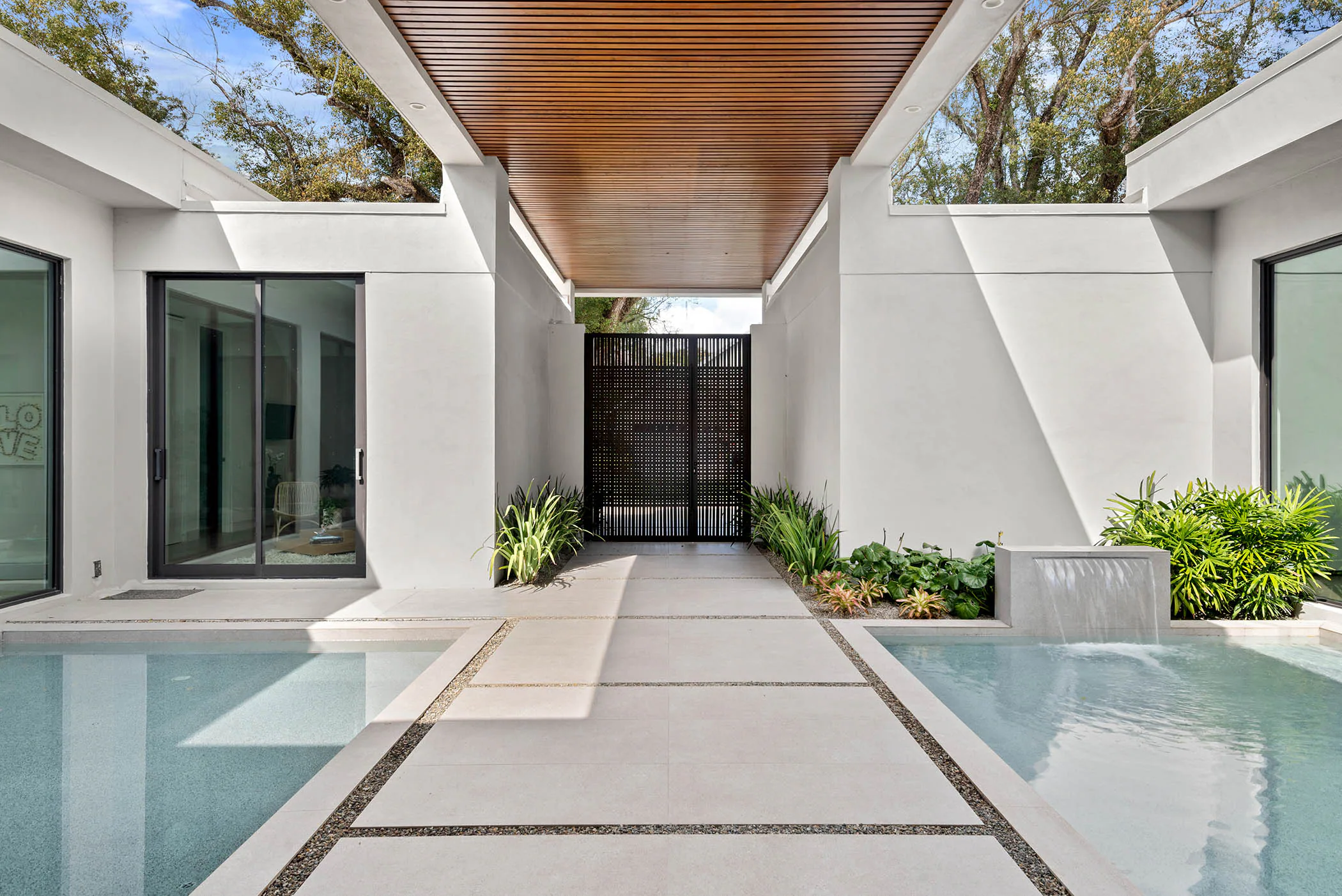 Courtyard pool beneath deep wood-lined roof overhangs.