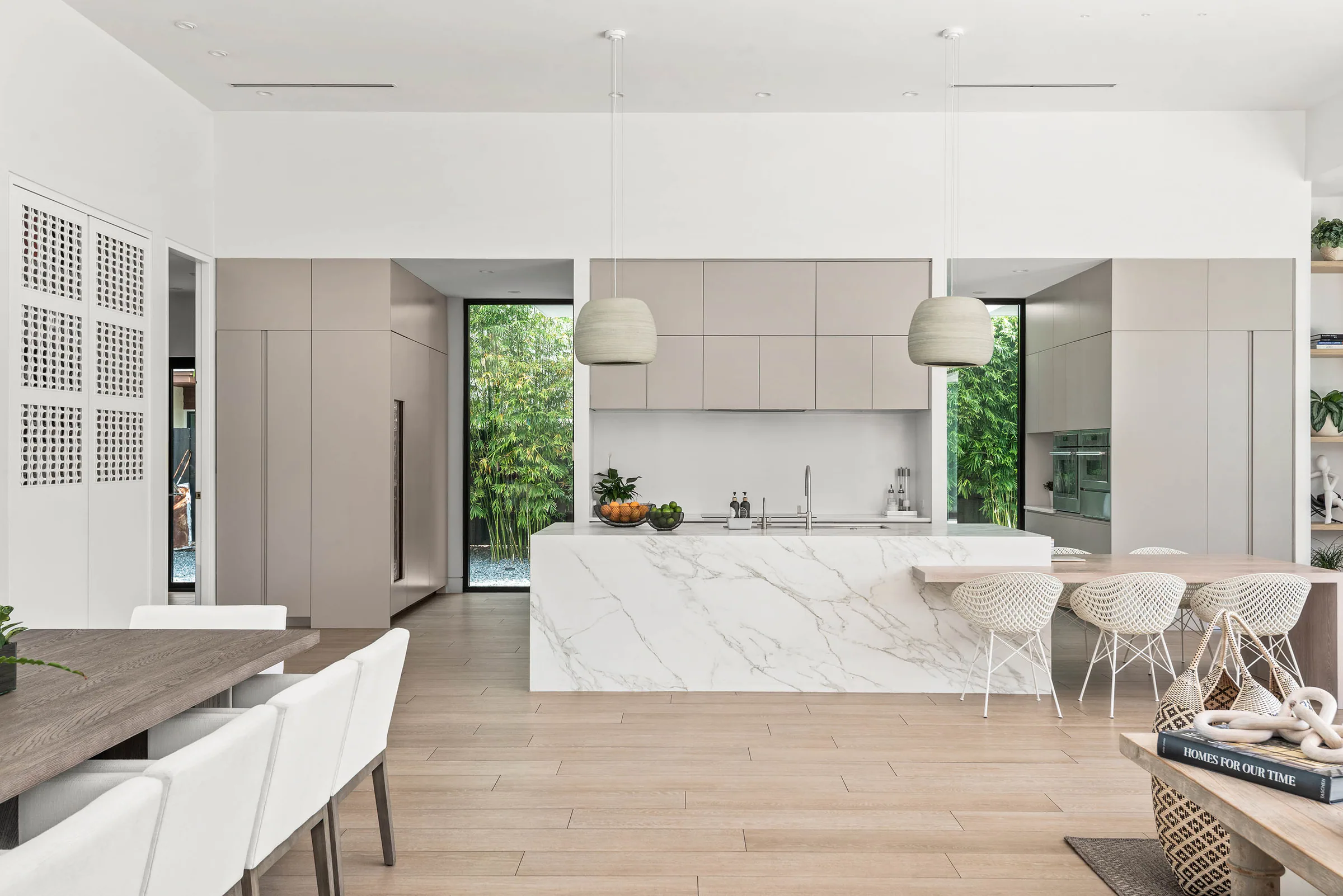 White kitchen island and pale cabinetry beside the dining area.