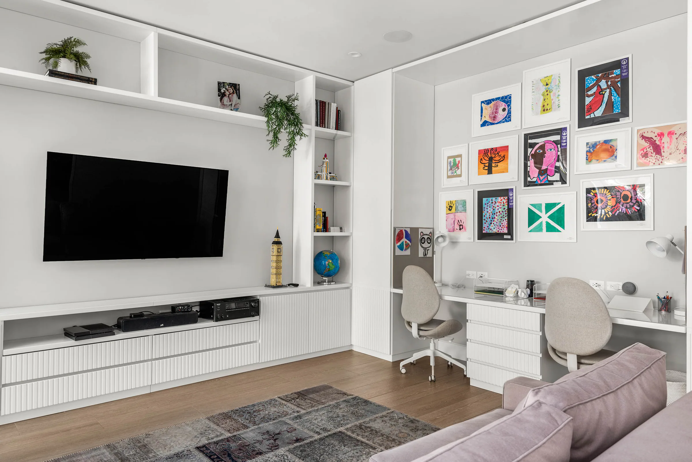 Children’s room with colorful framed artwork and low storage.