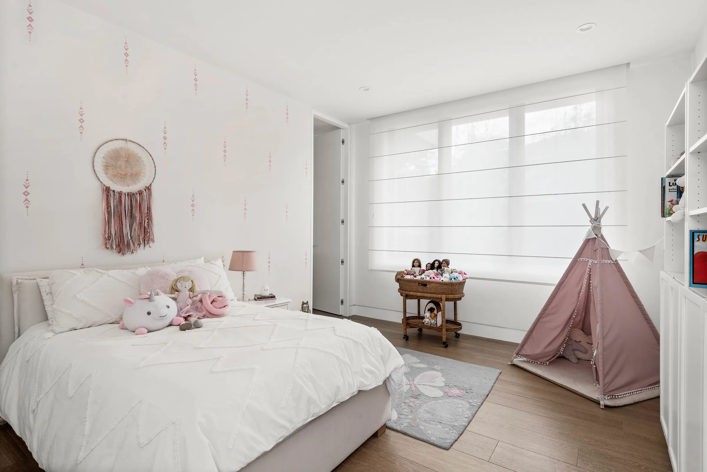Child’s bedroom with pale bedding and a small play tent.