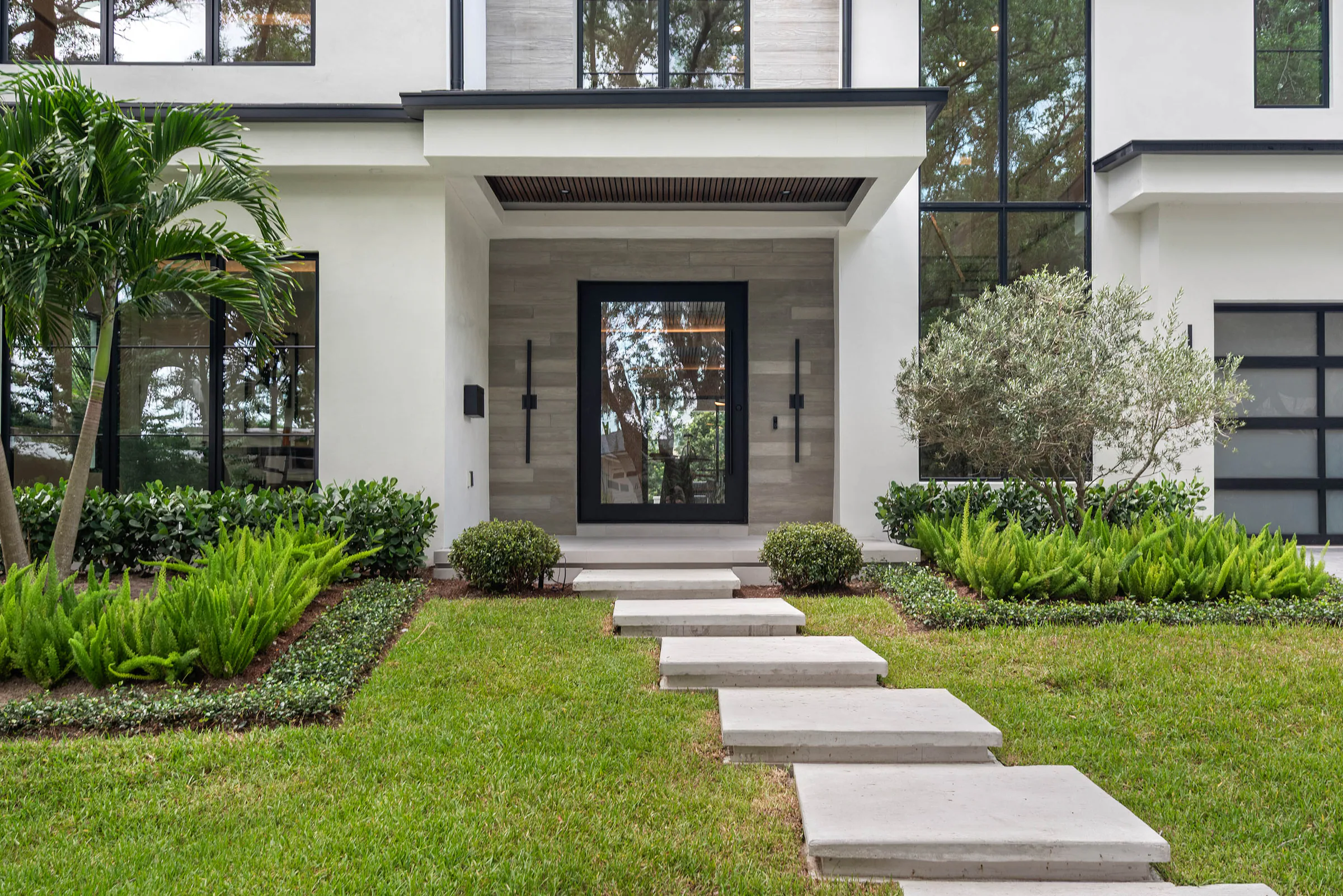 Floating concrete entry steps through layered front planting.