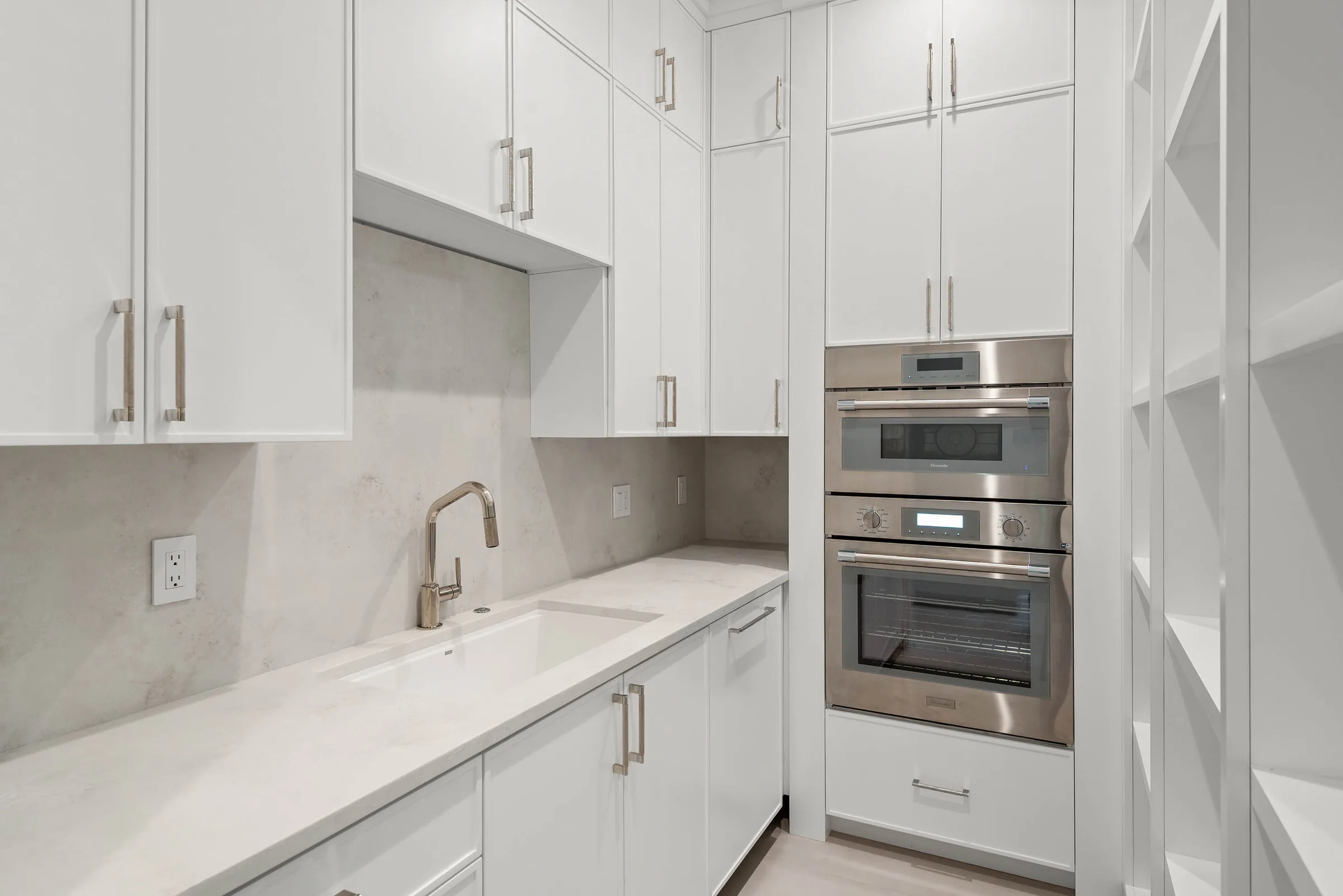 White utility cabinetry with integrated appliances.