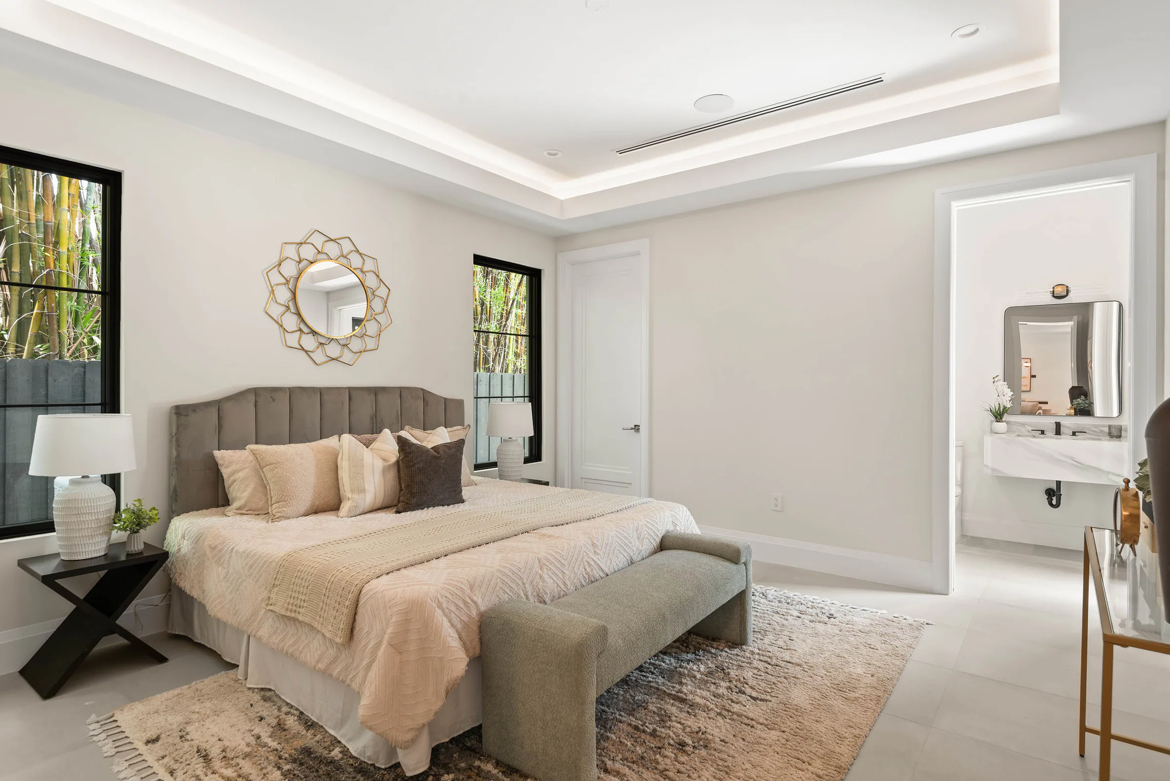 Bedroom with pale bedding and a window beside the headboard. Munster, a custom home by Rare Builders in Orlando.