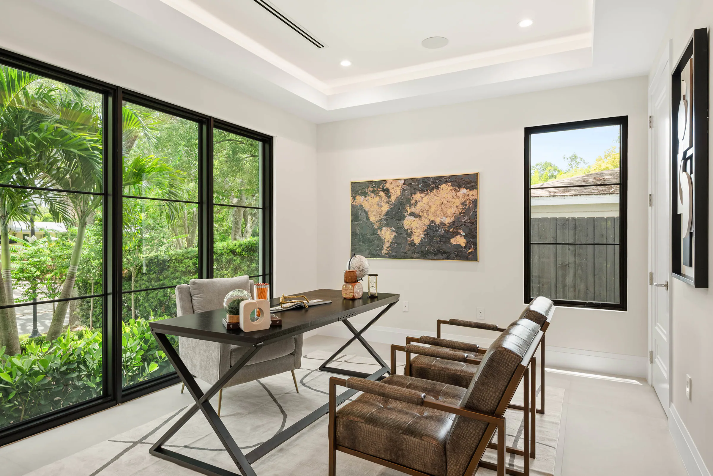 Small lounge with dark-framed garden doors and compact desk.