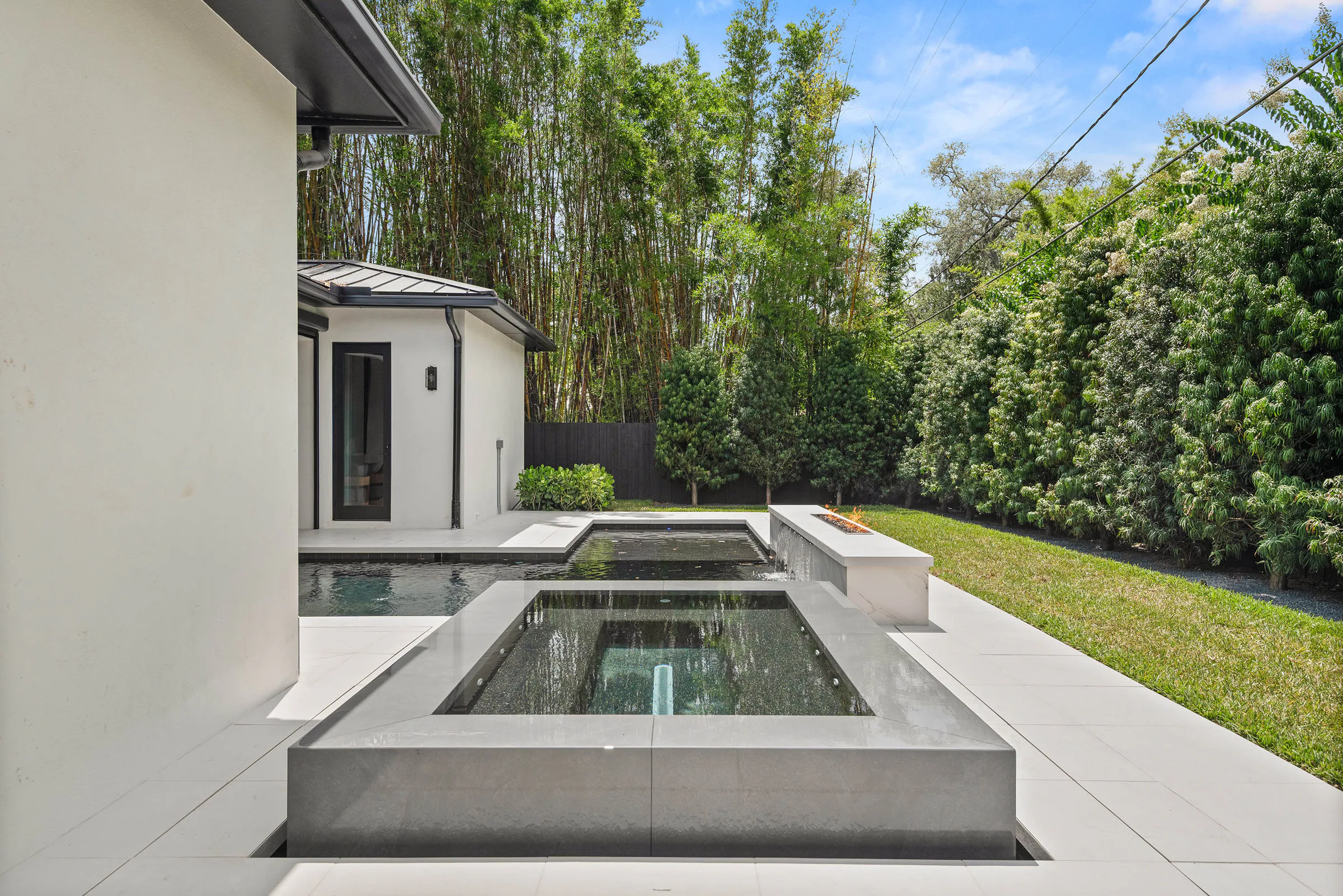 Spa and pool beside the covered rear pavilion. Munster, a custom home by Rare Builders in Orlando.
