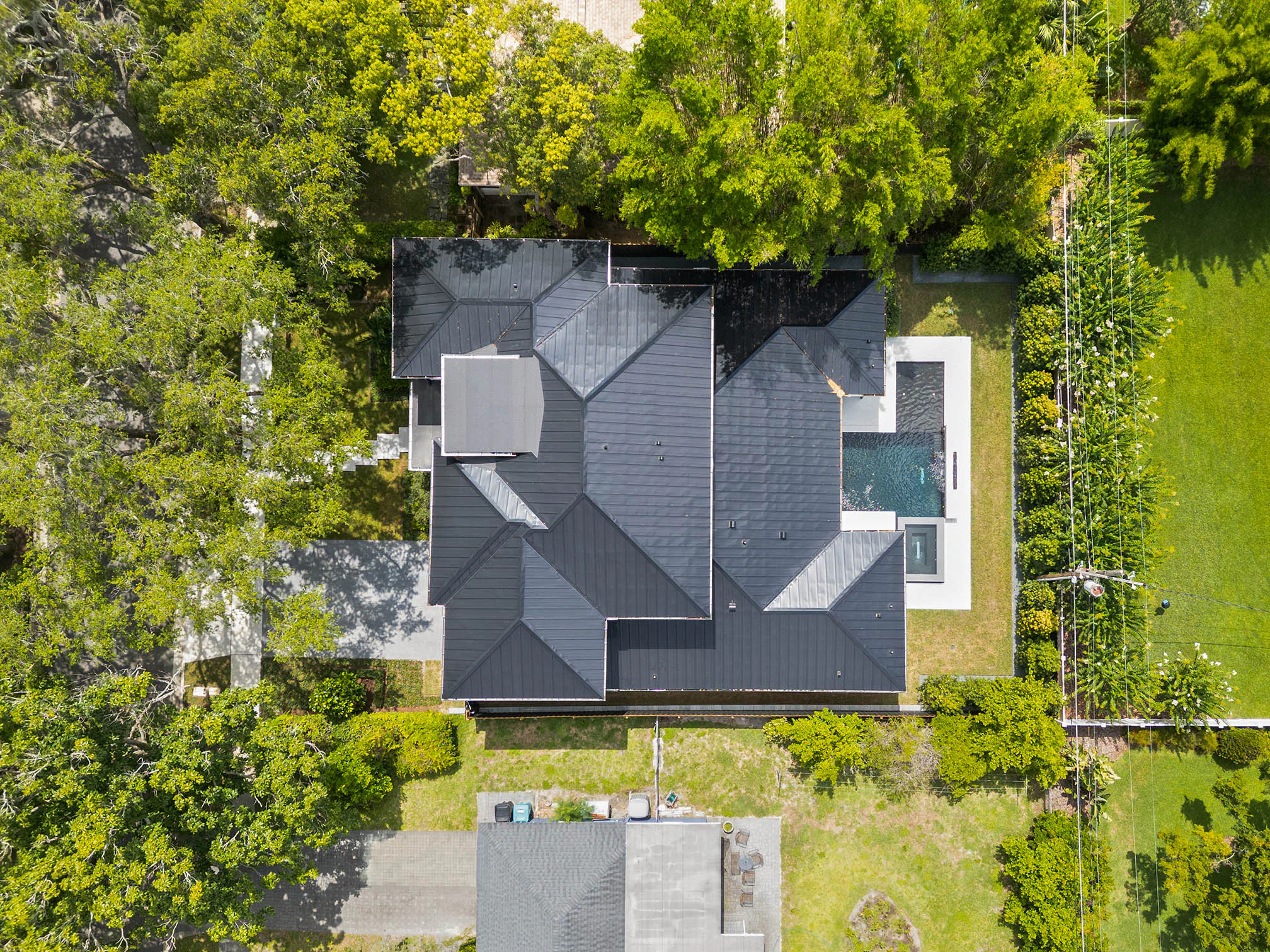 Straight-down aerial view of the roof and surrounding tree canopy.