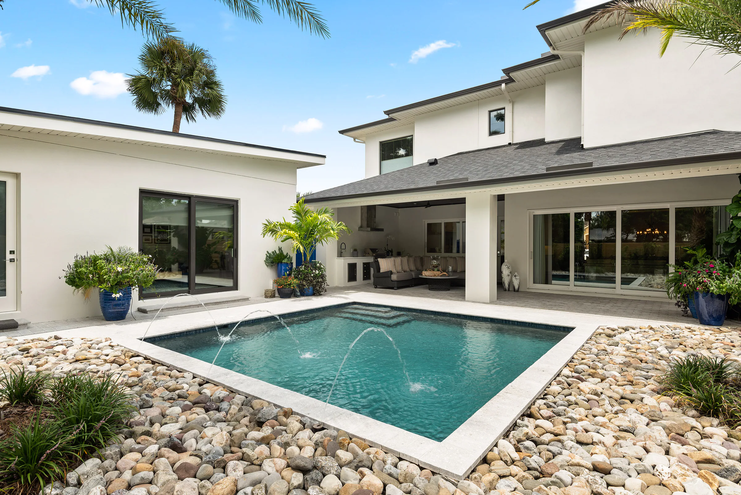 Rear elevation and rectangular pool beneath a clear sky. Nottingham, a custom home by Rare Builders in Orlando.