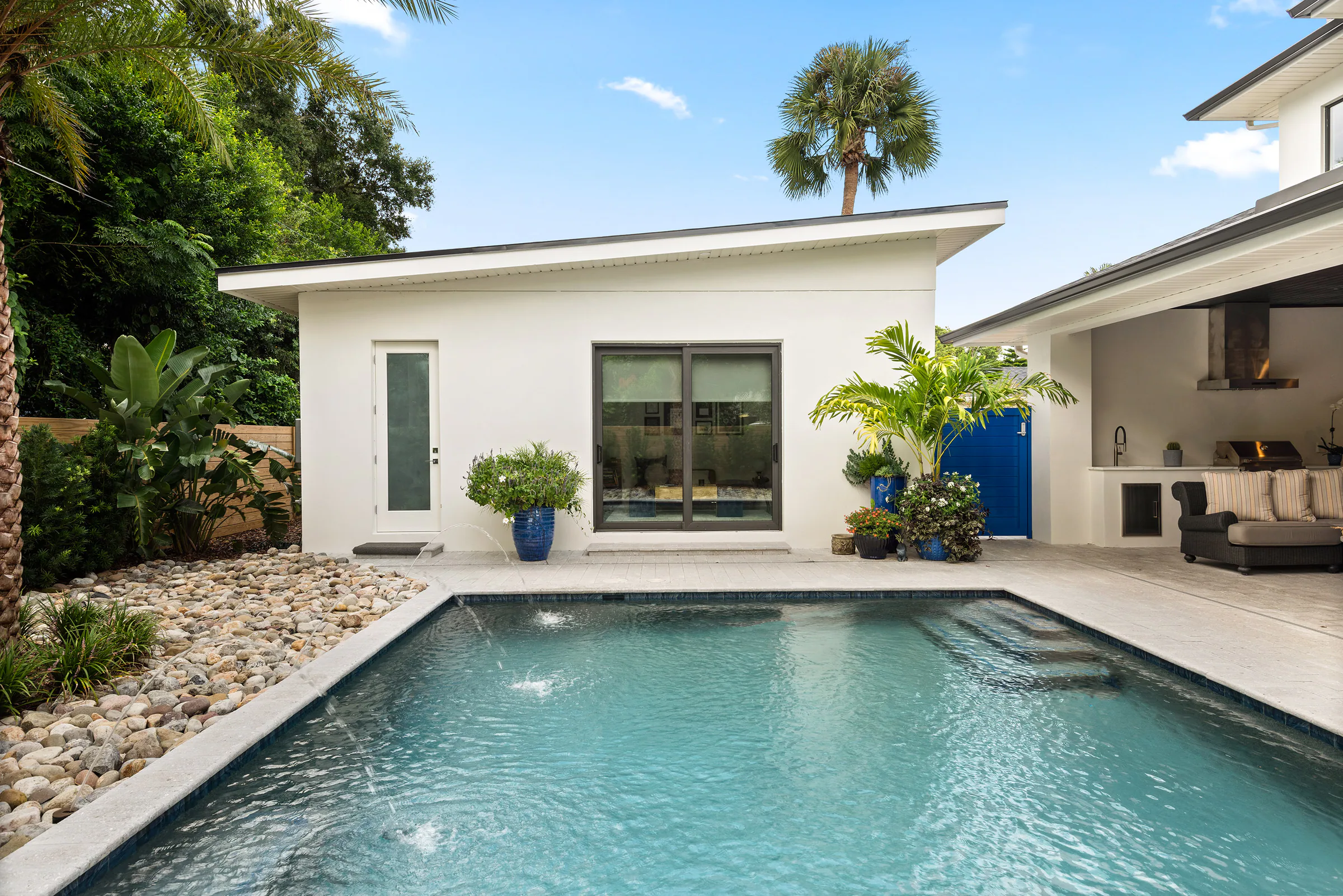 Pool and spa framed by pale paving and the rear terrace. Nottingham, a custom home by Rare Builders in Orlando.
