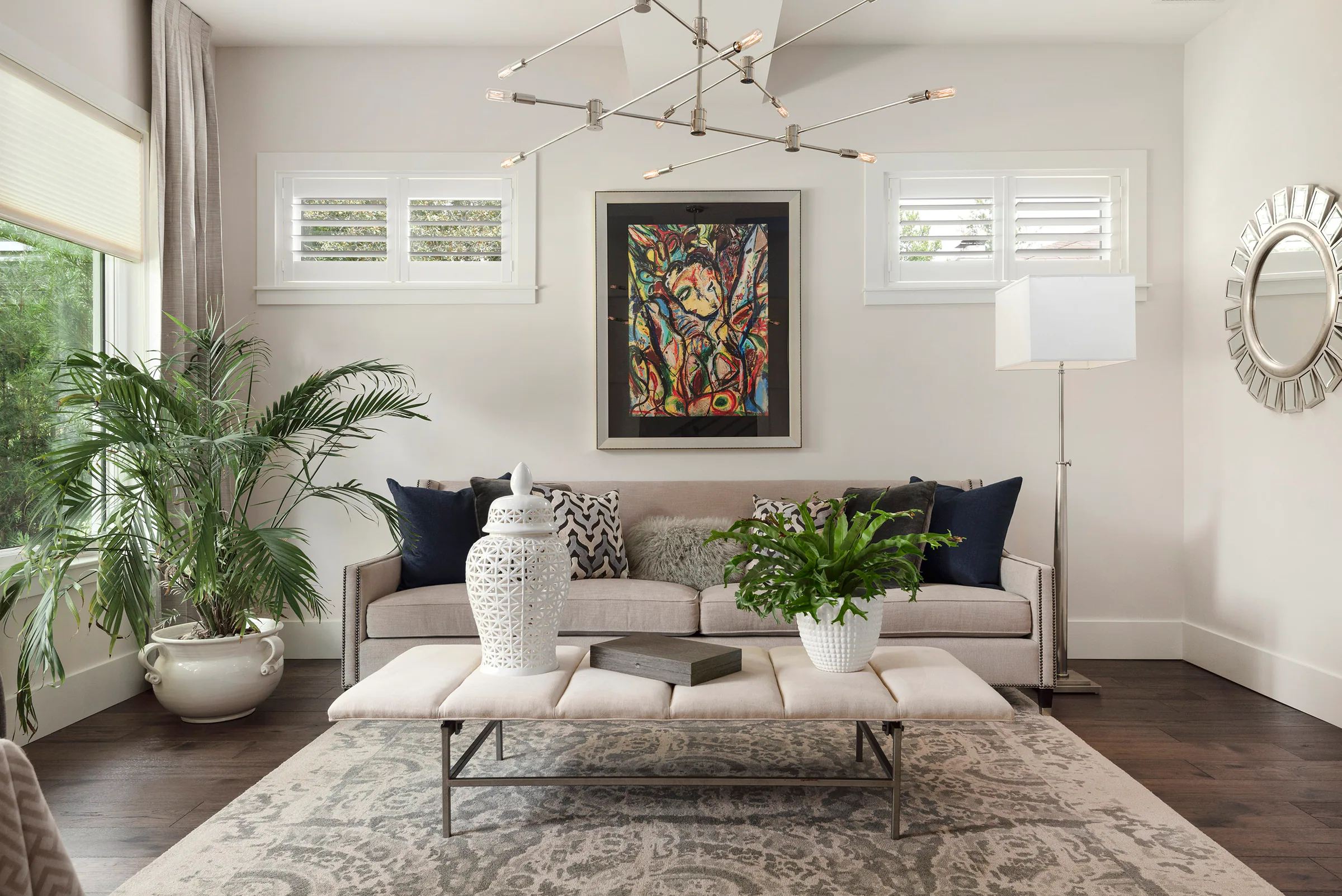 Living room with pale seating, dark wood flooring and garden doors.
