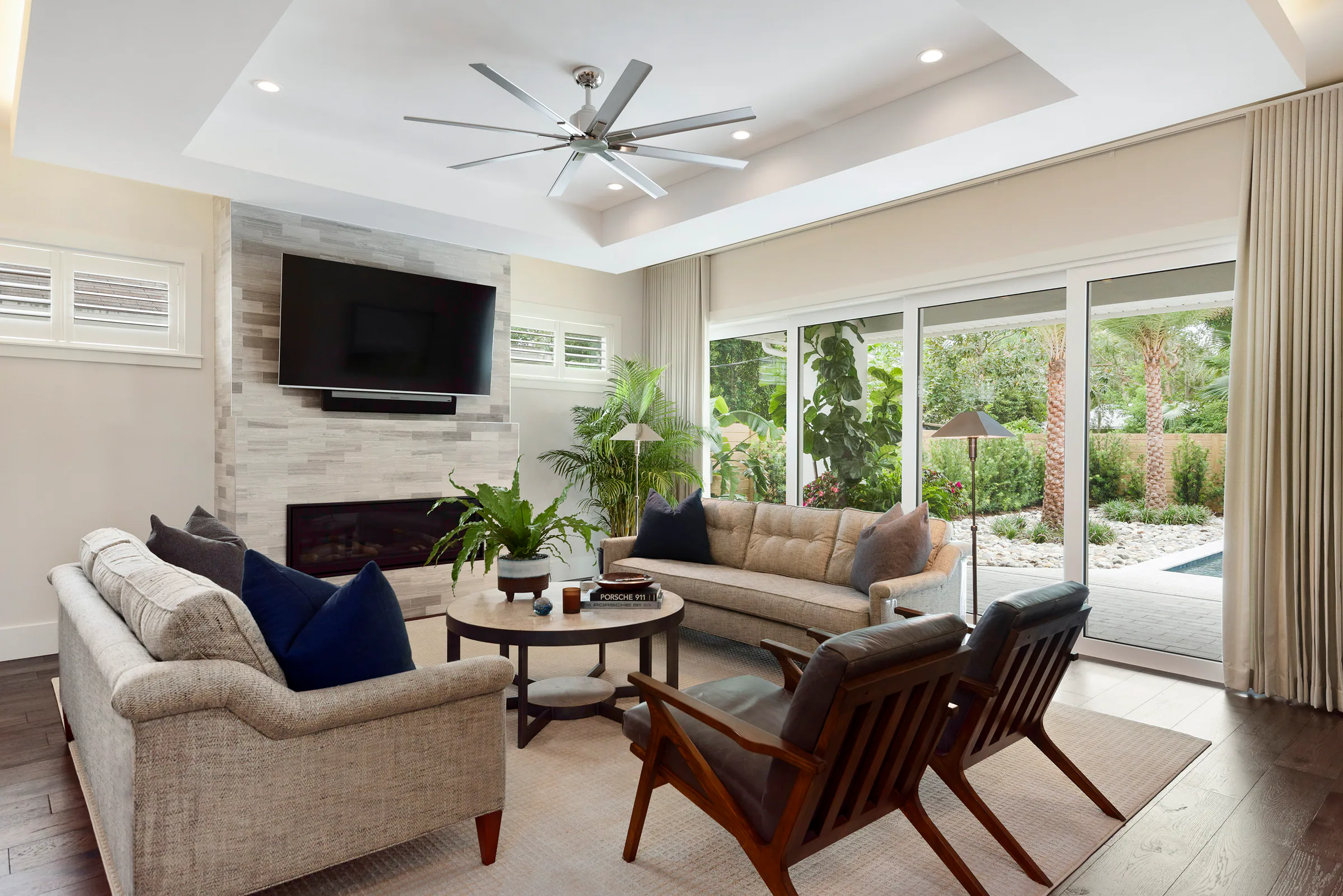 Family room with fireplace, television and broad rear windows. Nottingham, a custom home by Rare Builders in Orlando.