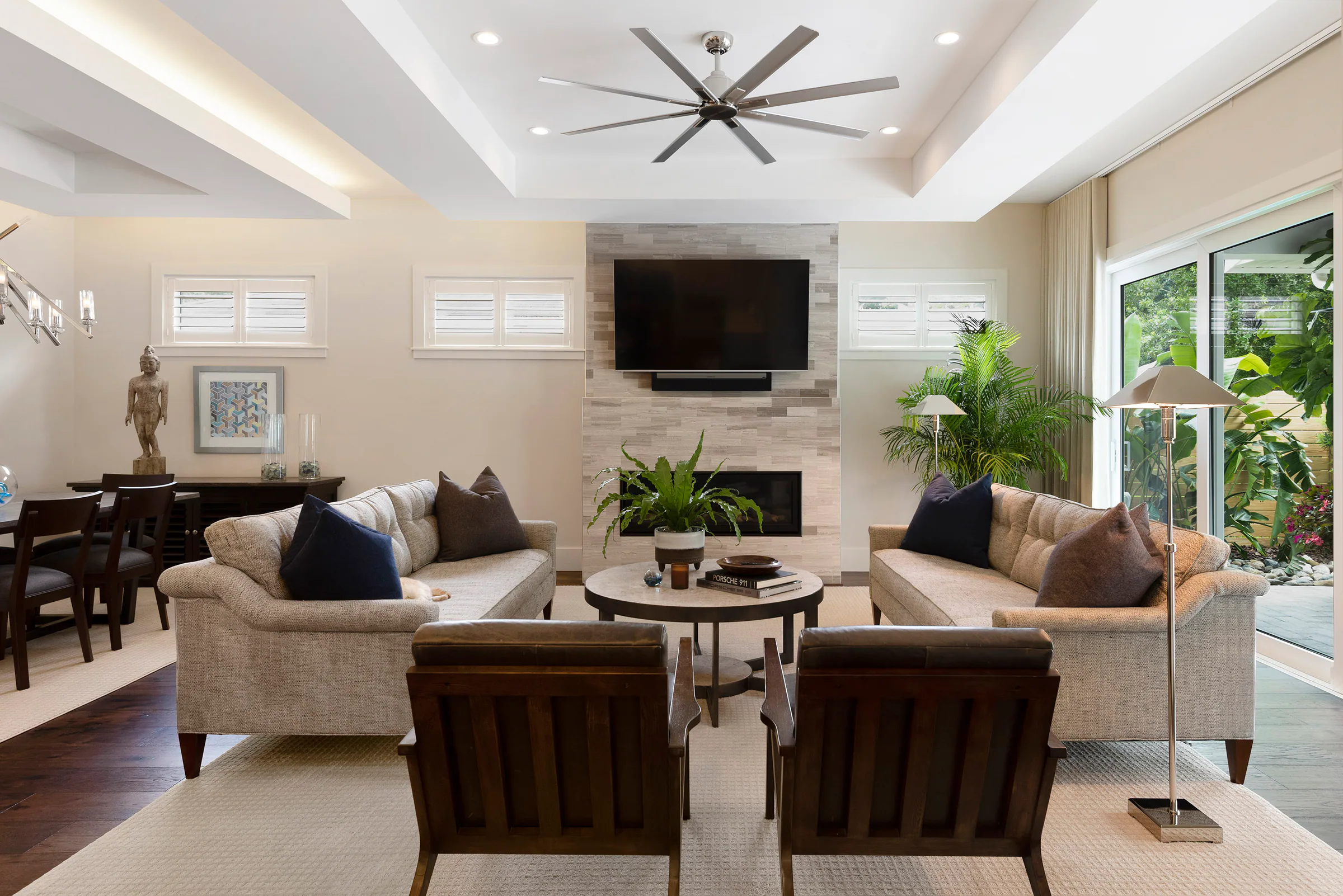 Living area with four lounge chairs and glass garden doors. Nottingham, a custom home by Rare Builders in Orlando.