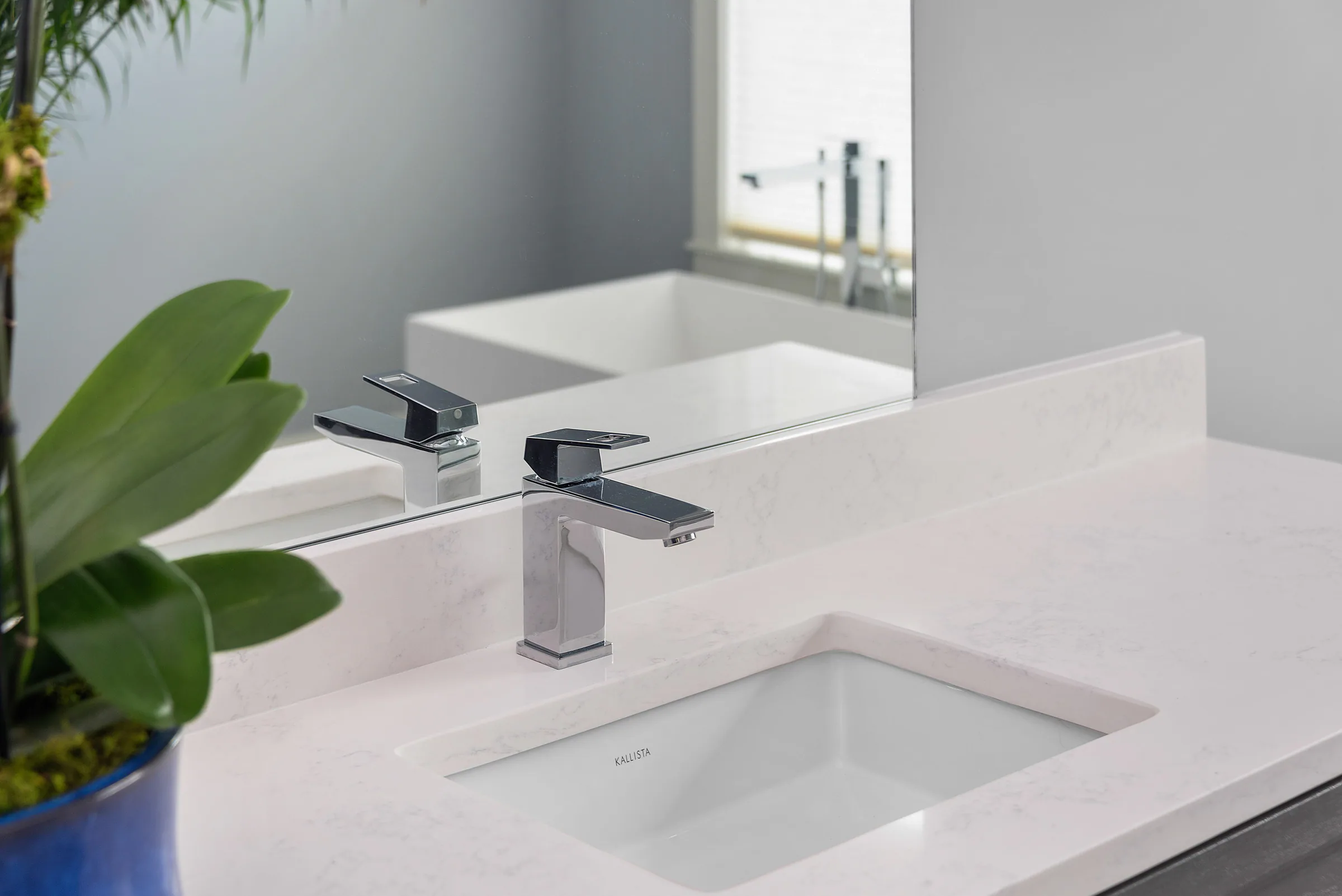 White vessel sink and wall-mounted dark faucet.