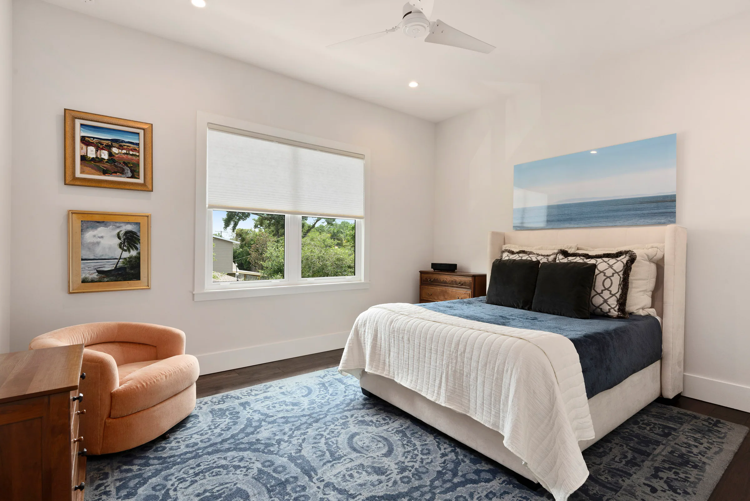 Bedroom with pale furnishings and blue accents. Nottingham, a custom home by Rare Builders in Orlando.