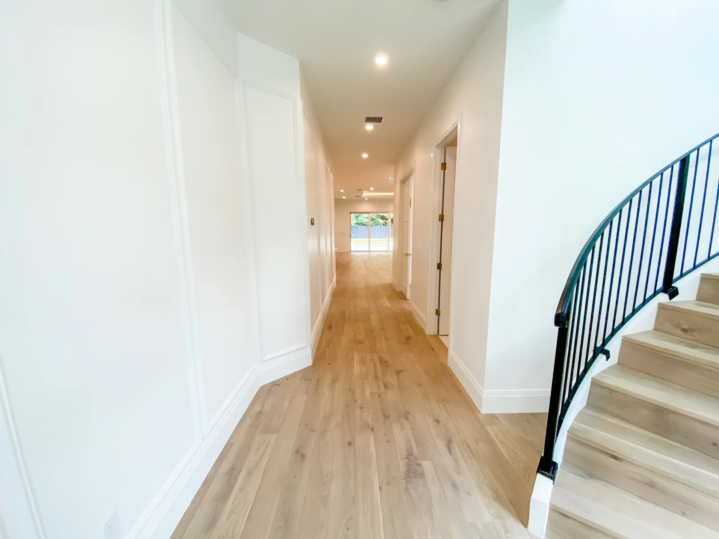 Westmoreland entry hall with light flooring, paneled walls and a curved staircase on the right.
