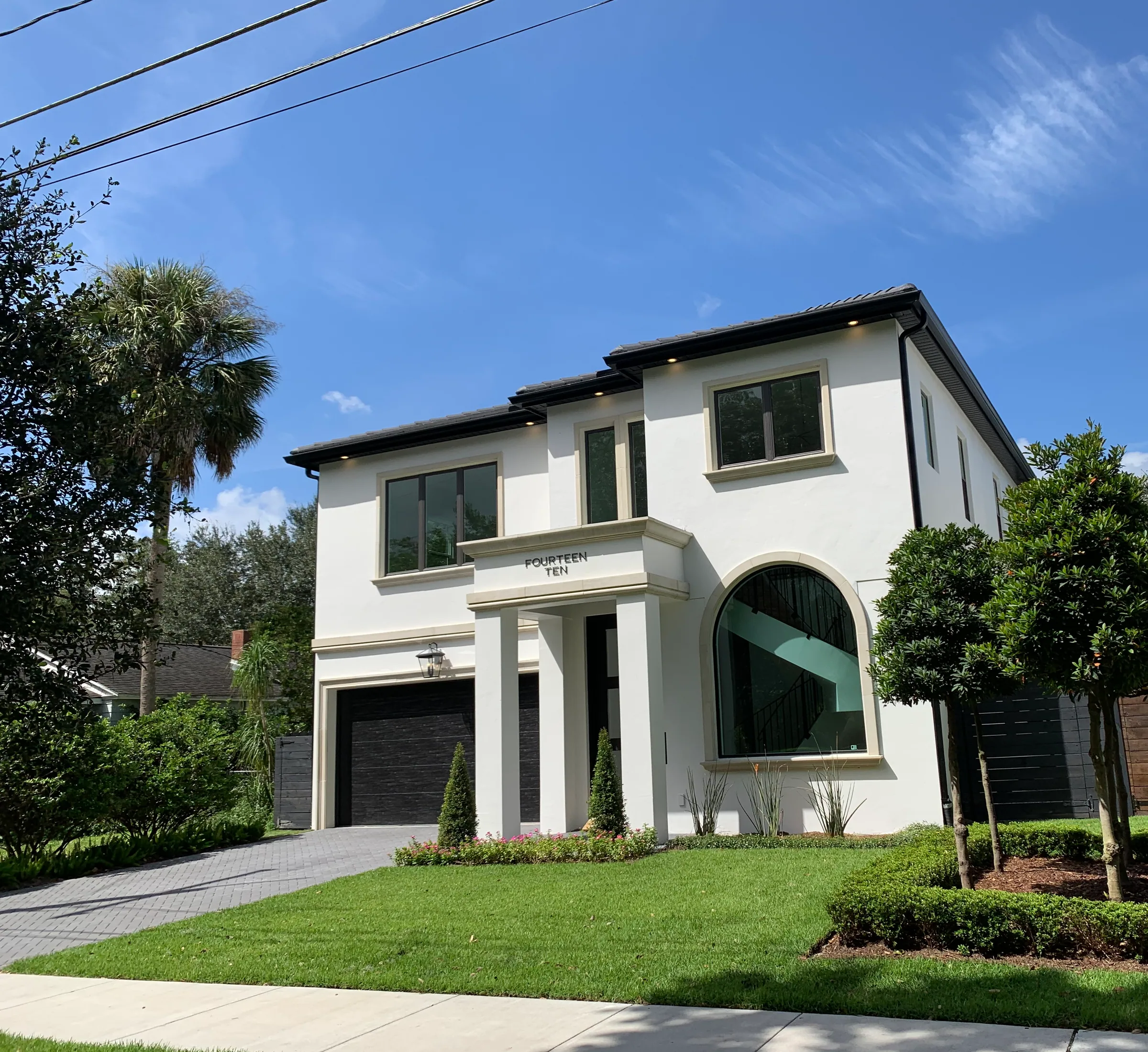 Westmoreland white two-story front elevation with a tall arched window, formal entry portico and garage.