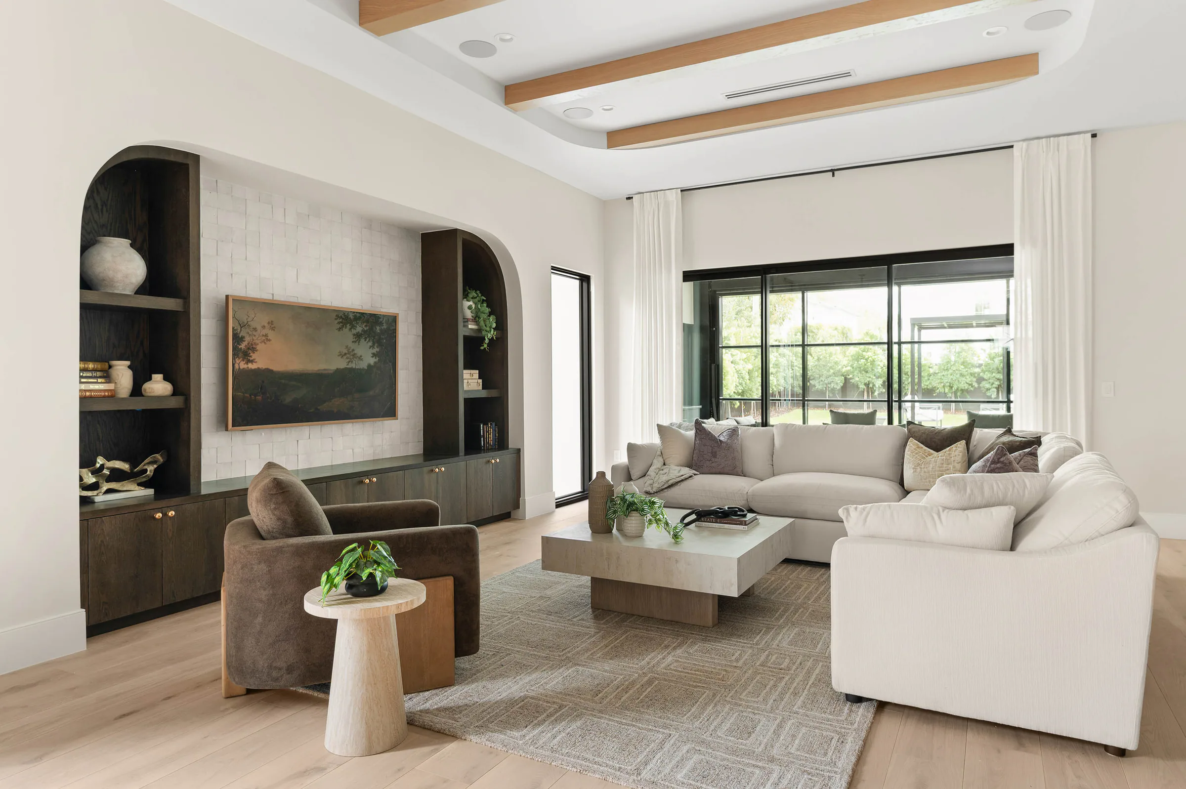 Living area centered on a tiled media wall and arched shelving.