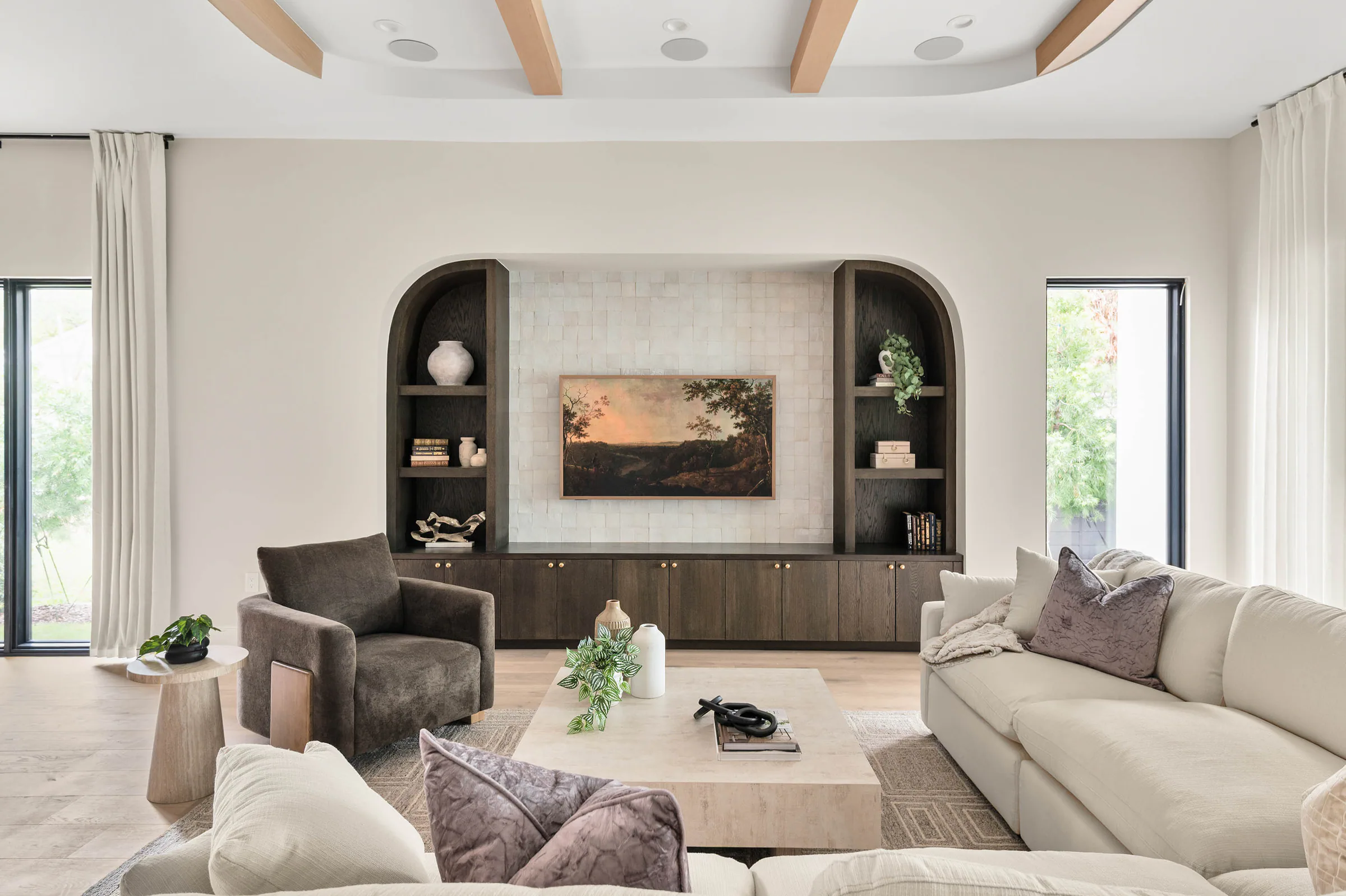 Pale sofas arranged around a stone coffee table beneath a beamed ceiling. Dana, a custom home by Rare Builders in Orlando.