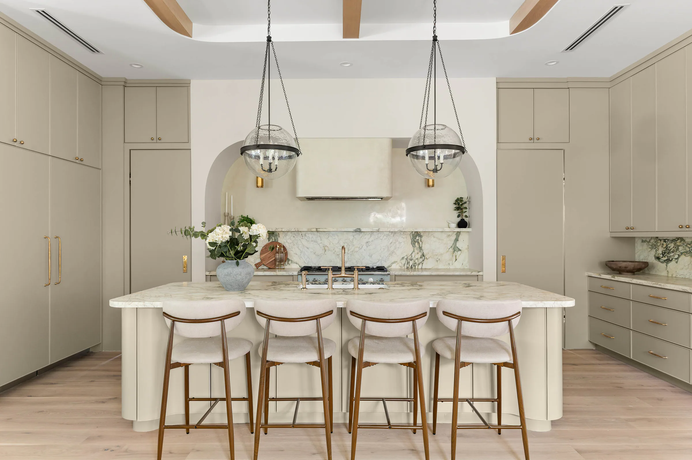 Kitchen island centered beneath glass globe pendants. Dana, a custom home by Rare Builders in Orlando.