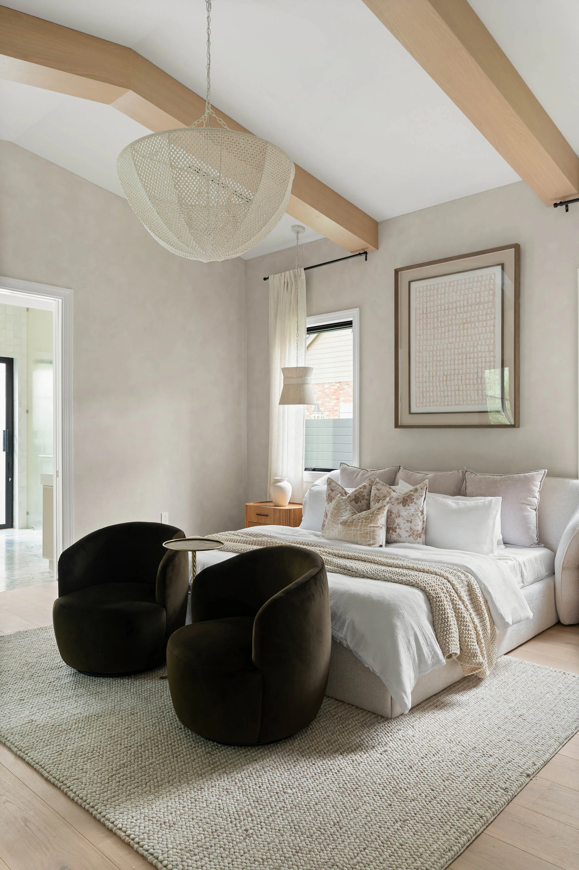 Bedroom with a plaster fireplace and windows on two sides. Dana, a custom home by Rare Builders in Orlando.