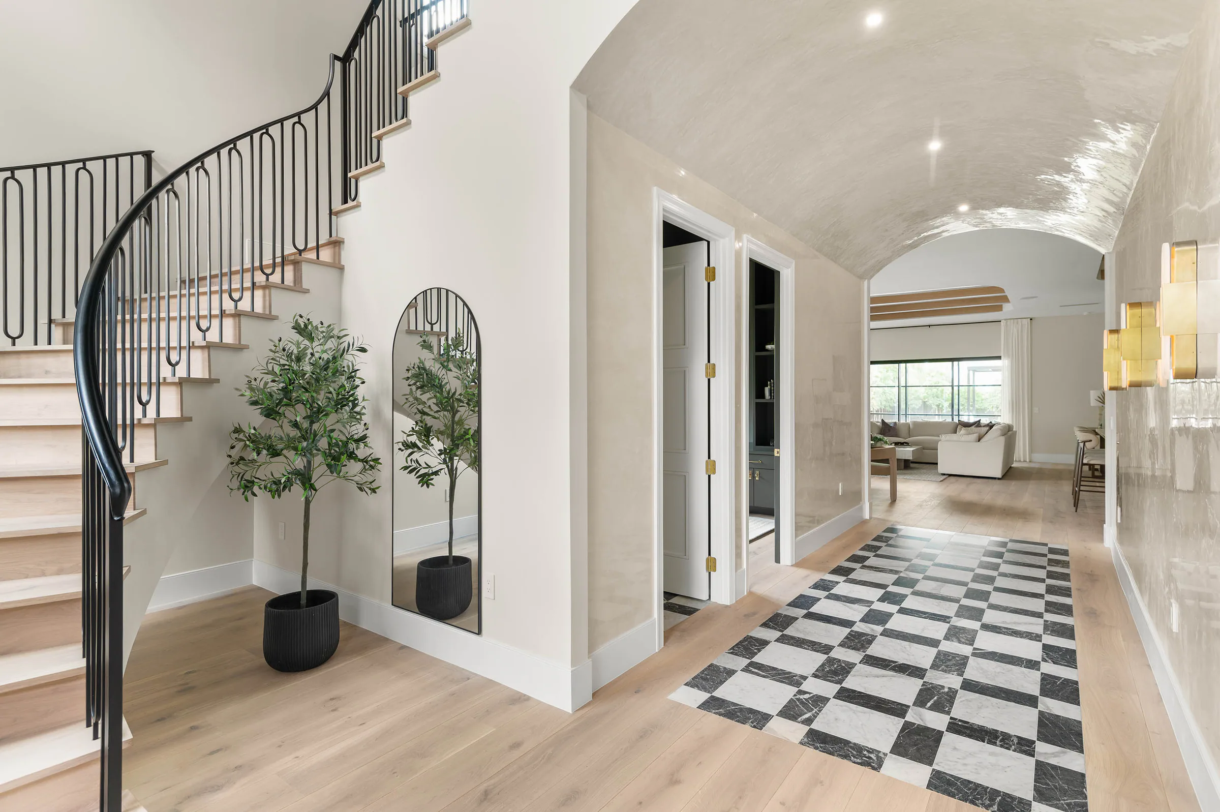 Curved stair and black-and-white tiled entry hall.