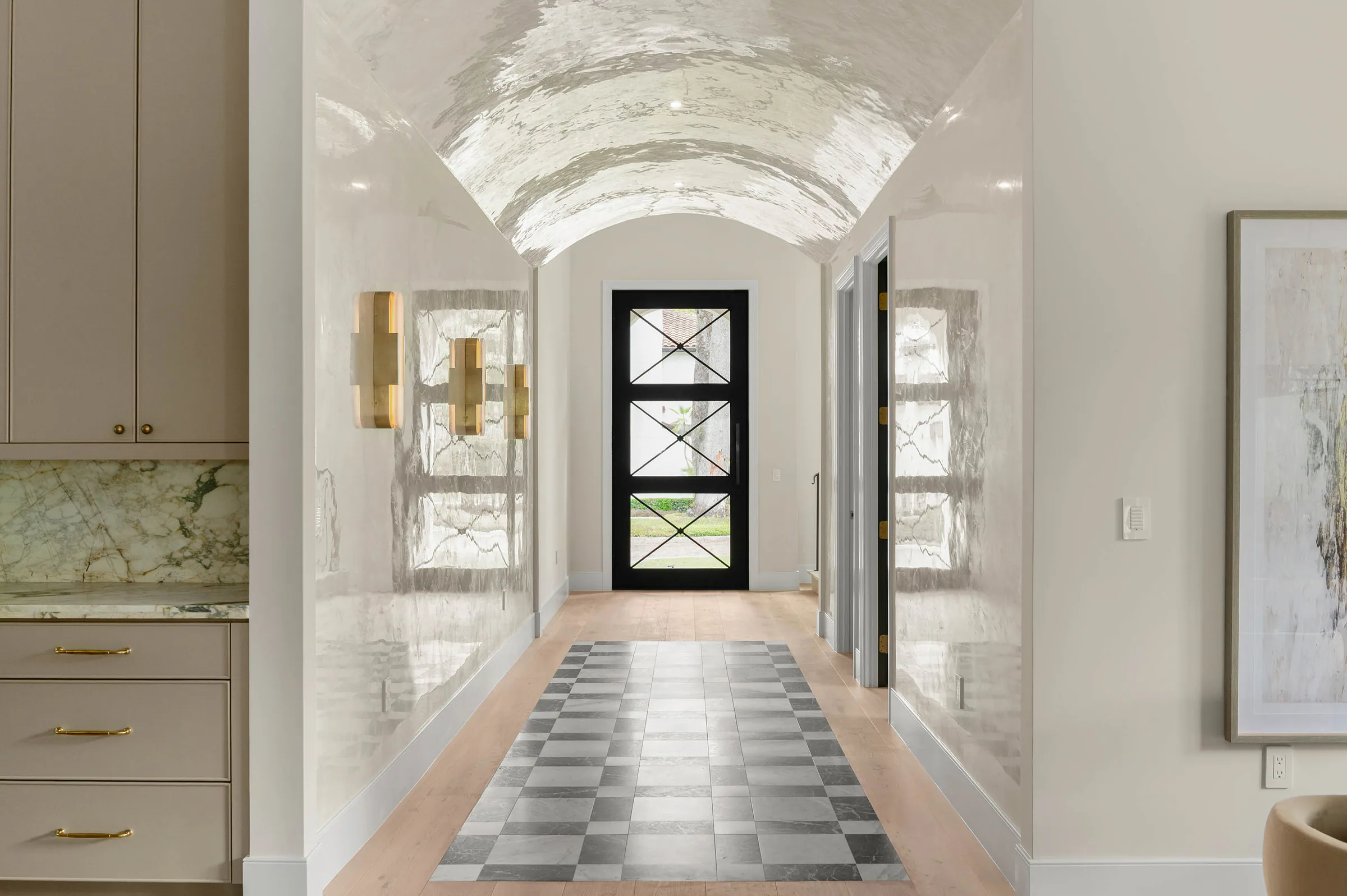 Long hall terminating at the arched black front door.