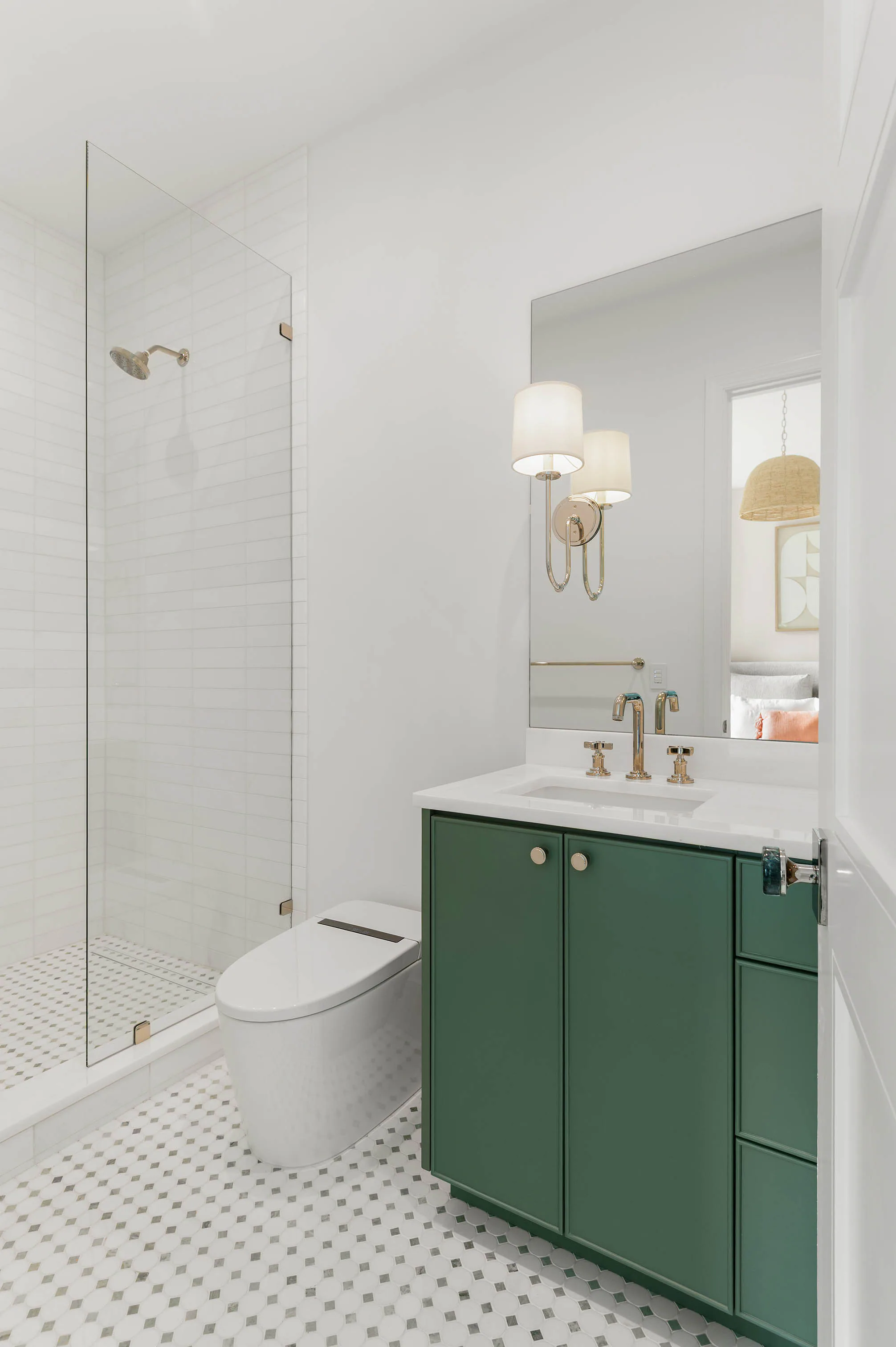 White bathroom with green vanity and glass shower. Dana, a custom home by Rare Builders in Orlando.