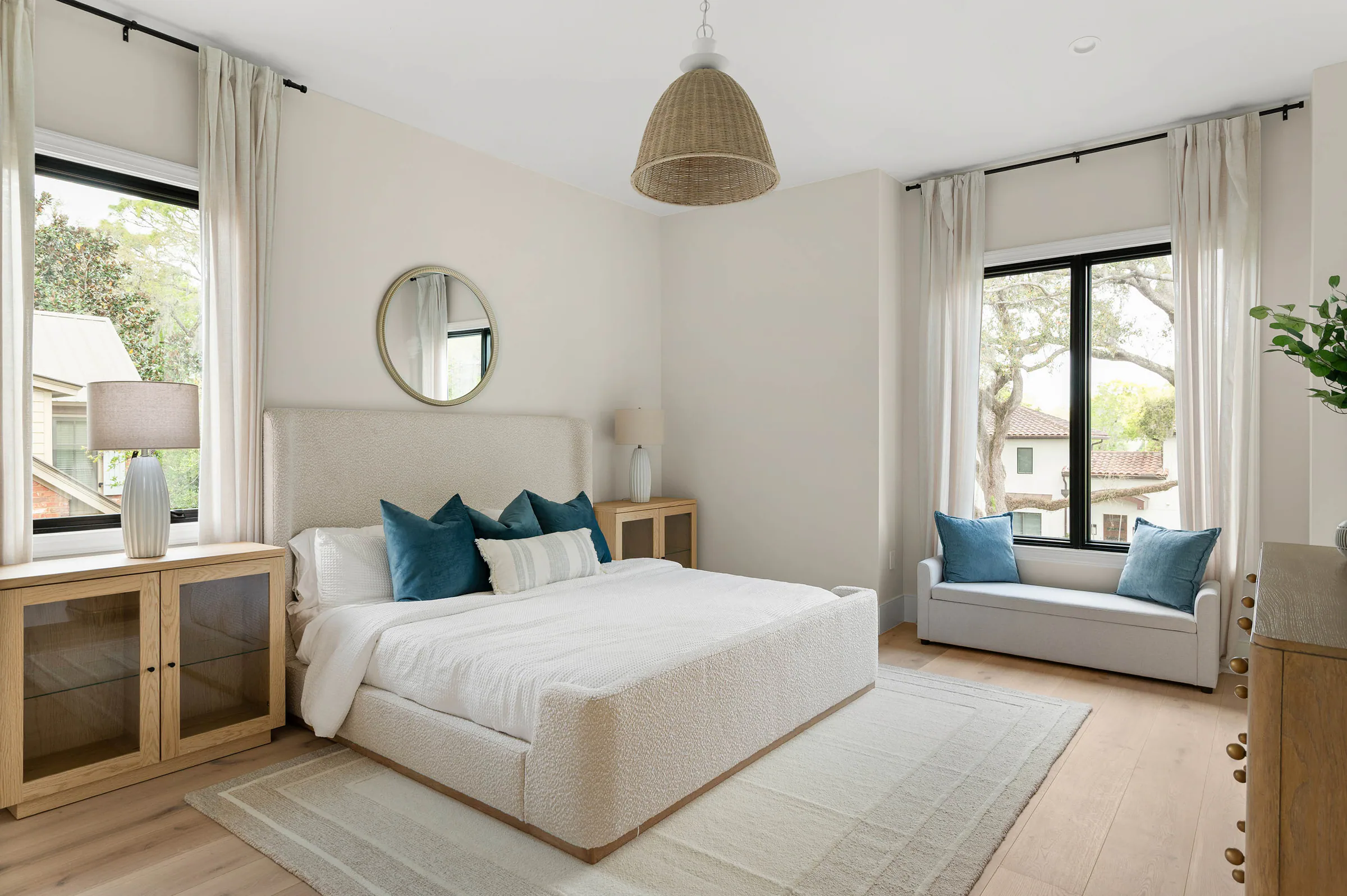 Bedroom with a window seat and pale wood flooring. Dana, a custom home by Rare Builders in Orlando.