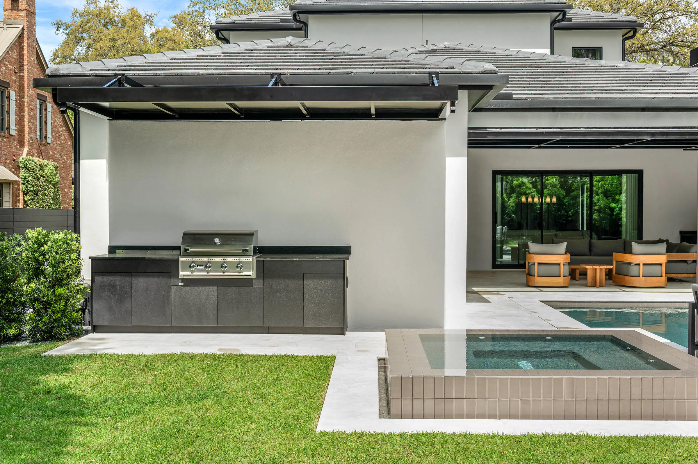Covered outdoor lounge with wood ceiling and pool view. Dana, a custom home by Rare Builders in Orlando.