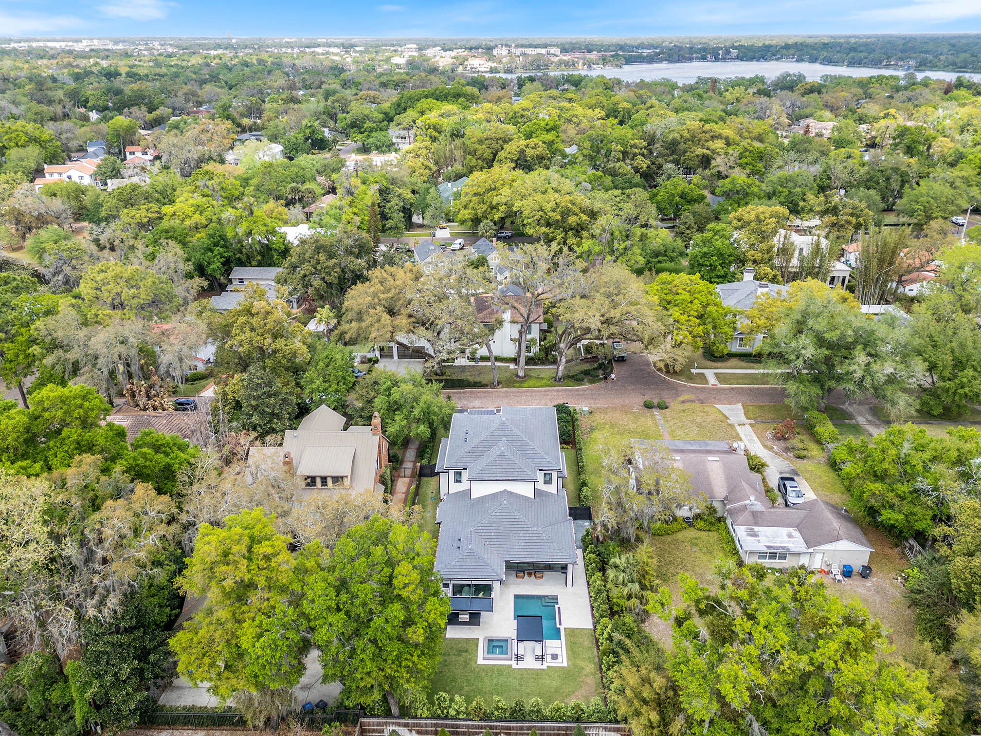 Aerial neighborhood view with the residence and pool centered.