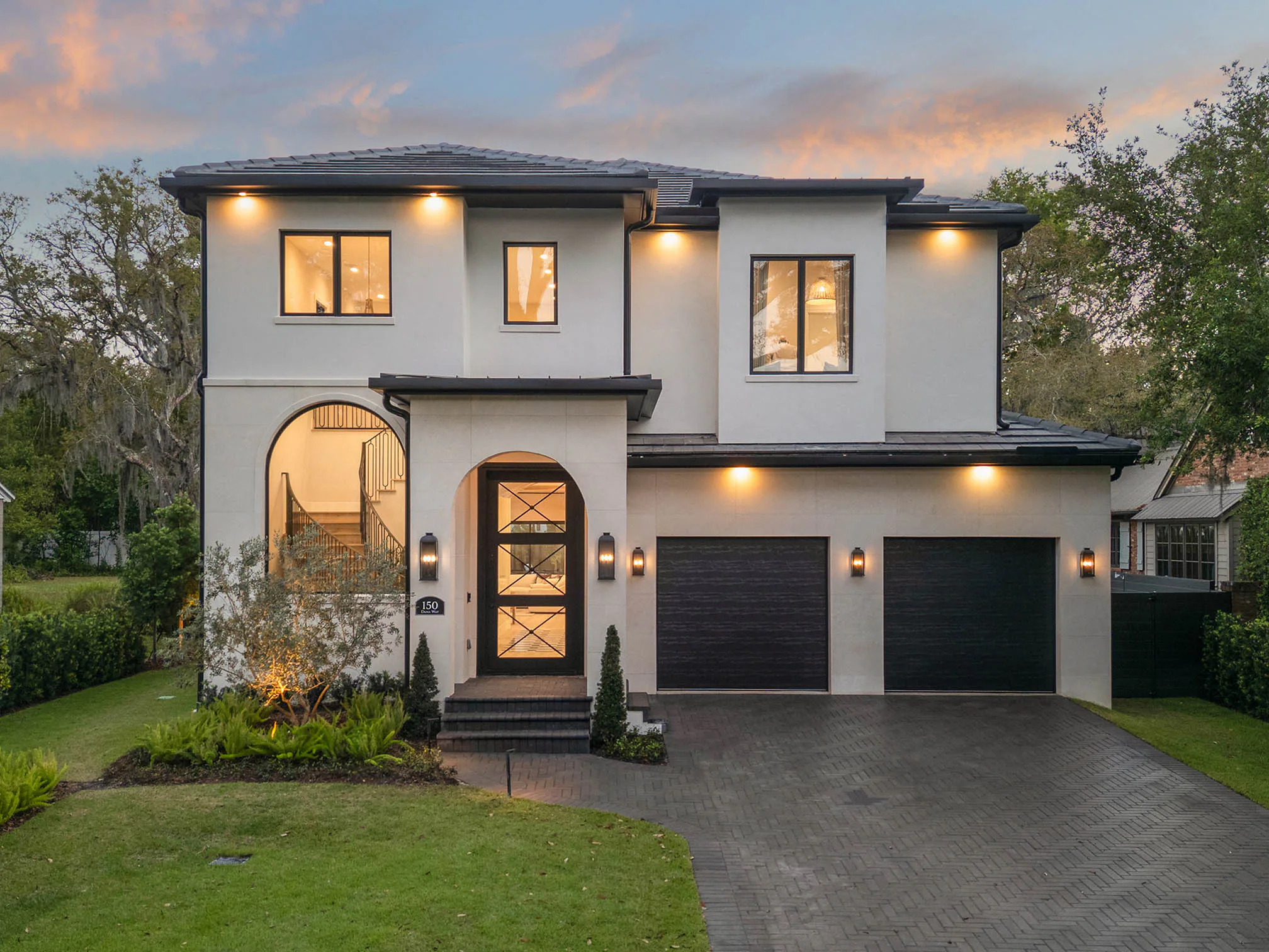 Front elevation illuminated beneath a blue-hour sky.