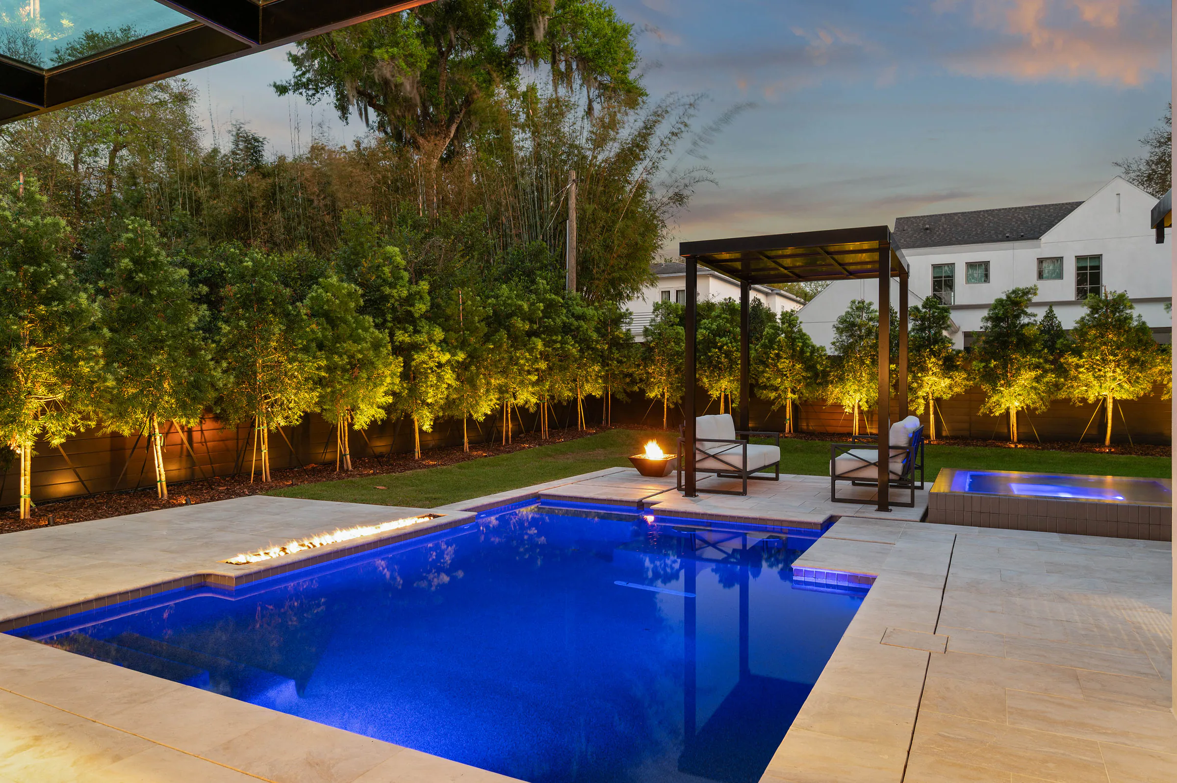 Pool and pergola glowing at dusk. Dana, a custom home by Rare Builders in Orlando.