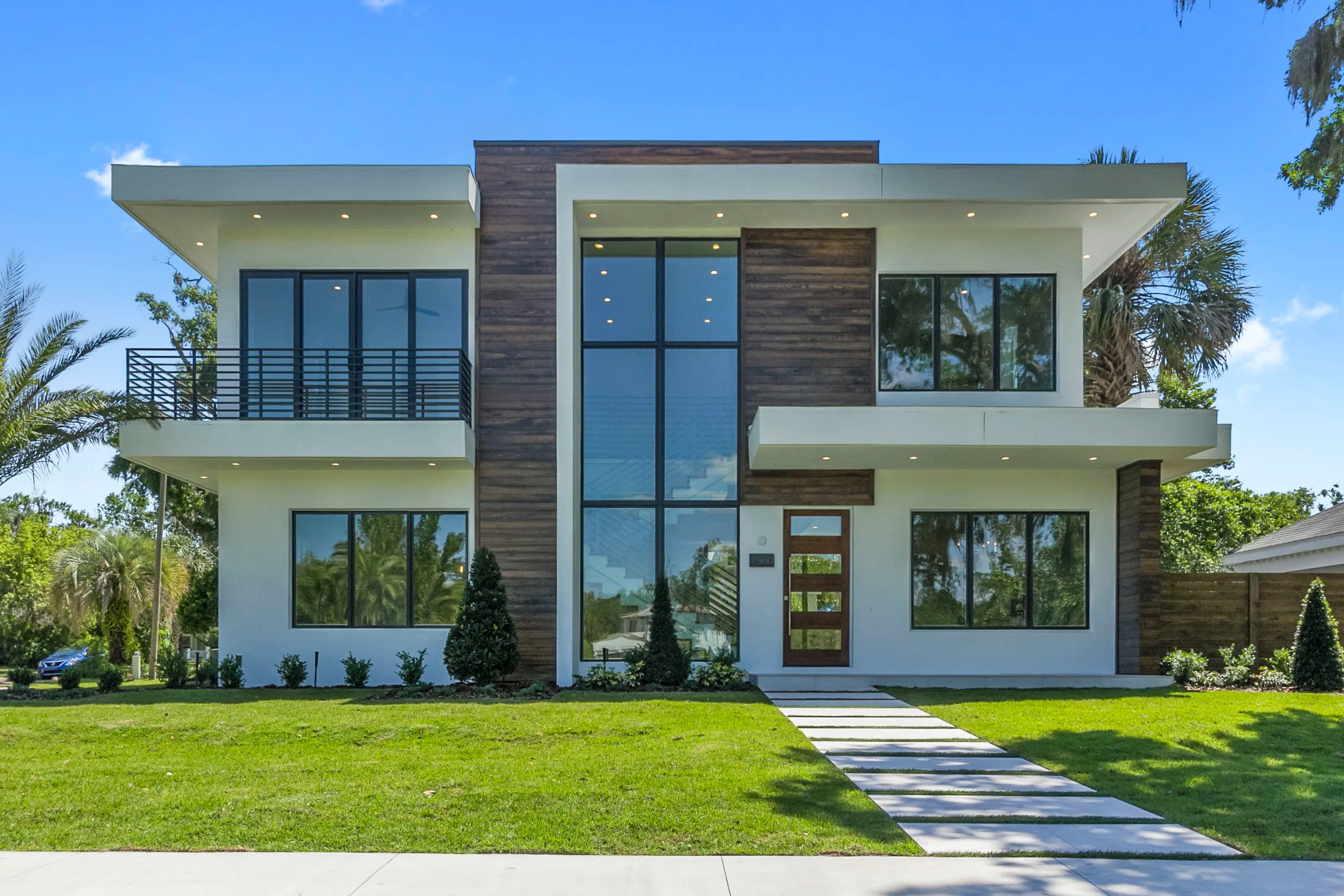 Wilbar’s two-story white front elevation with broad roof overhangs, dark-framed windows and a tall glazed entry.