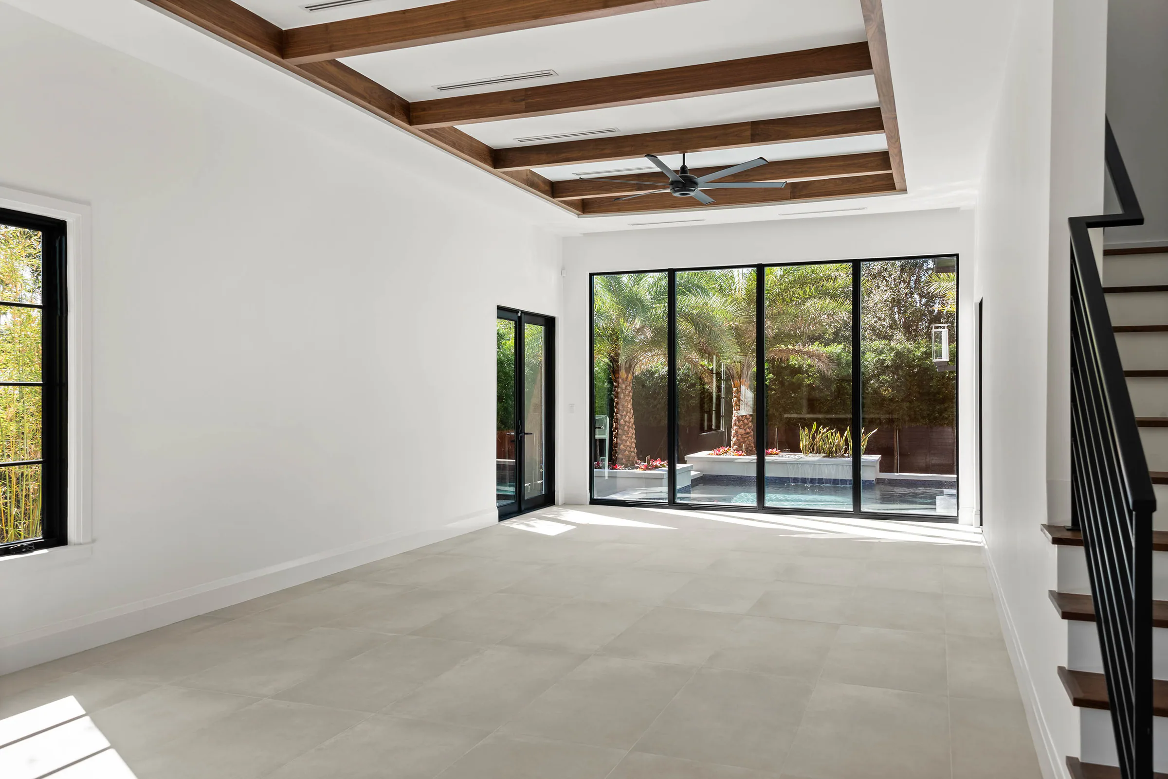 Unfurnished living space beneath a wood-trimmed ceiling opening.