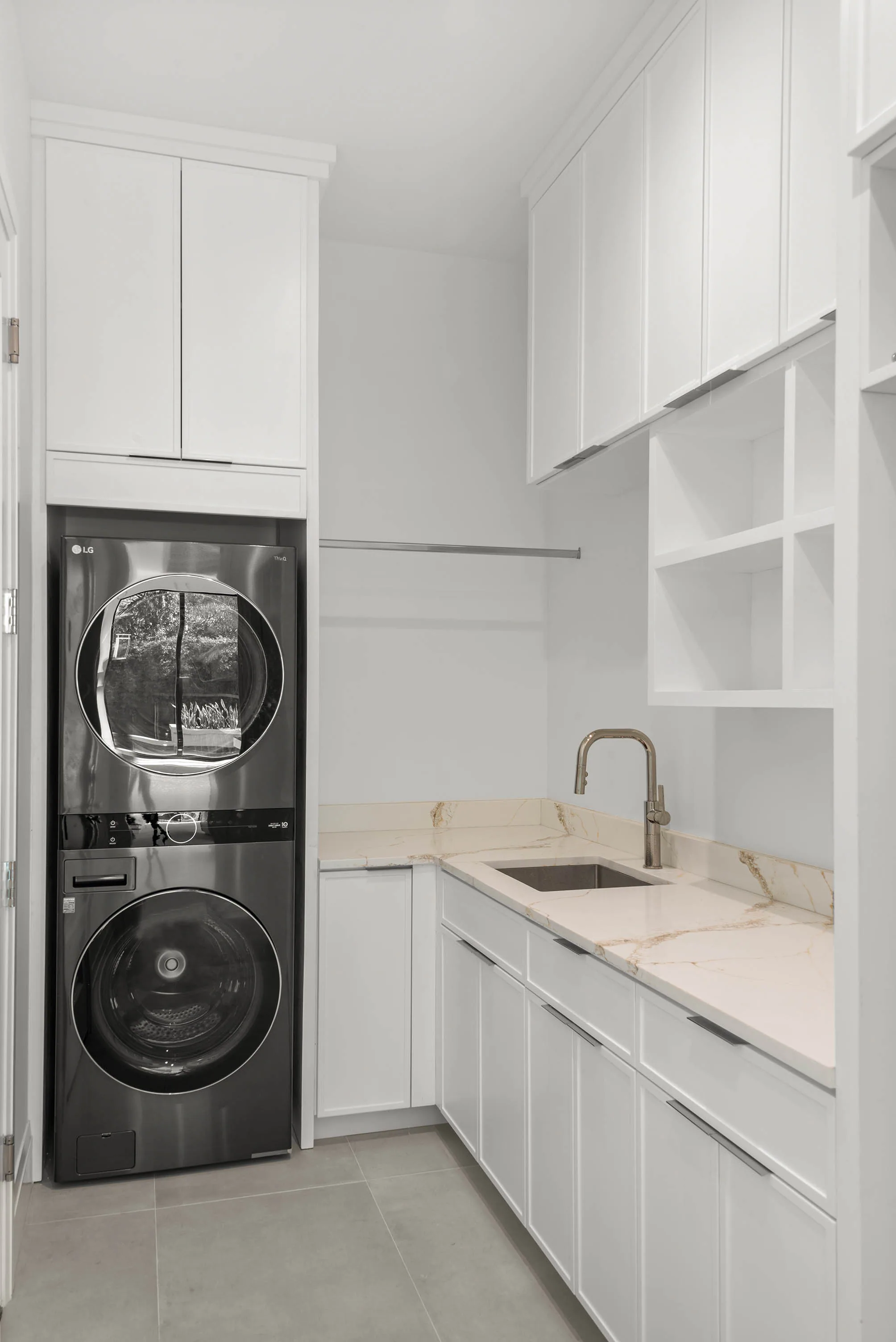 Compact laundry room with white cabinetry.
