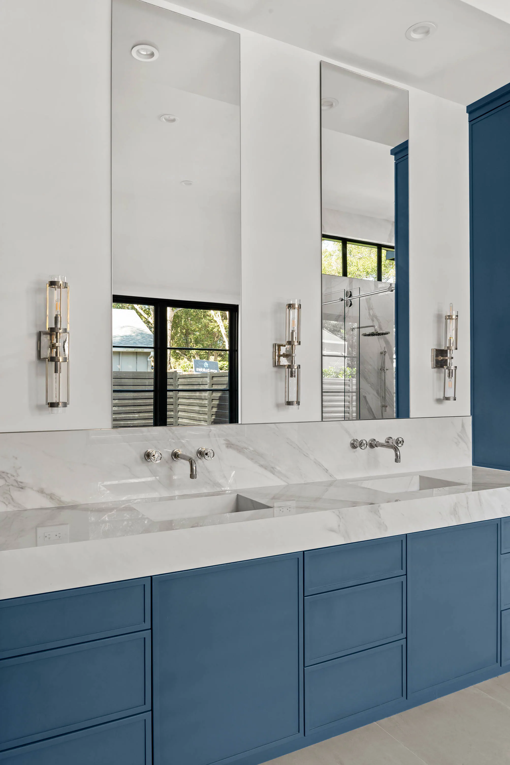 Blue vanity and marble floor in the primary bathroom.