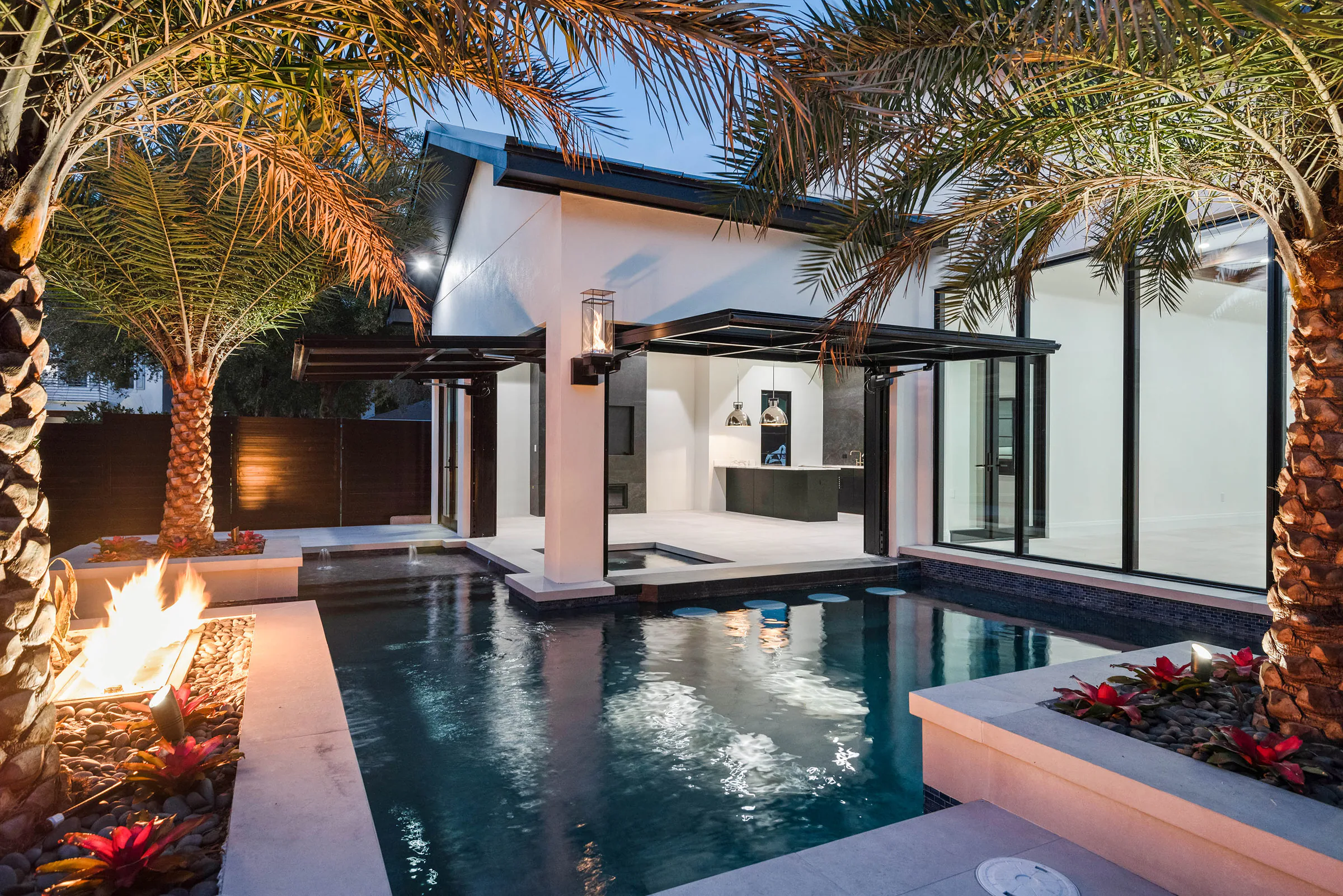 Pool, palm and rear pavilion reflected at blue hour.