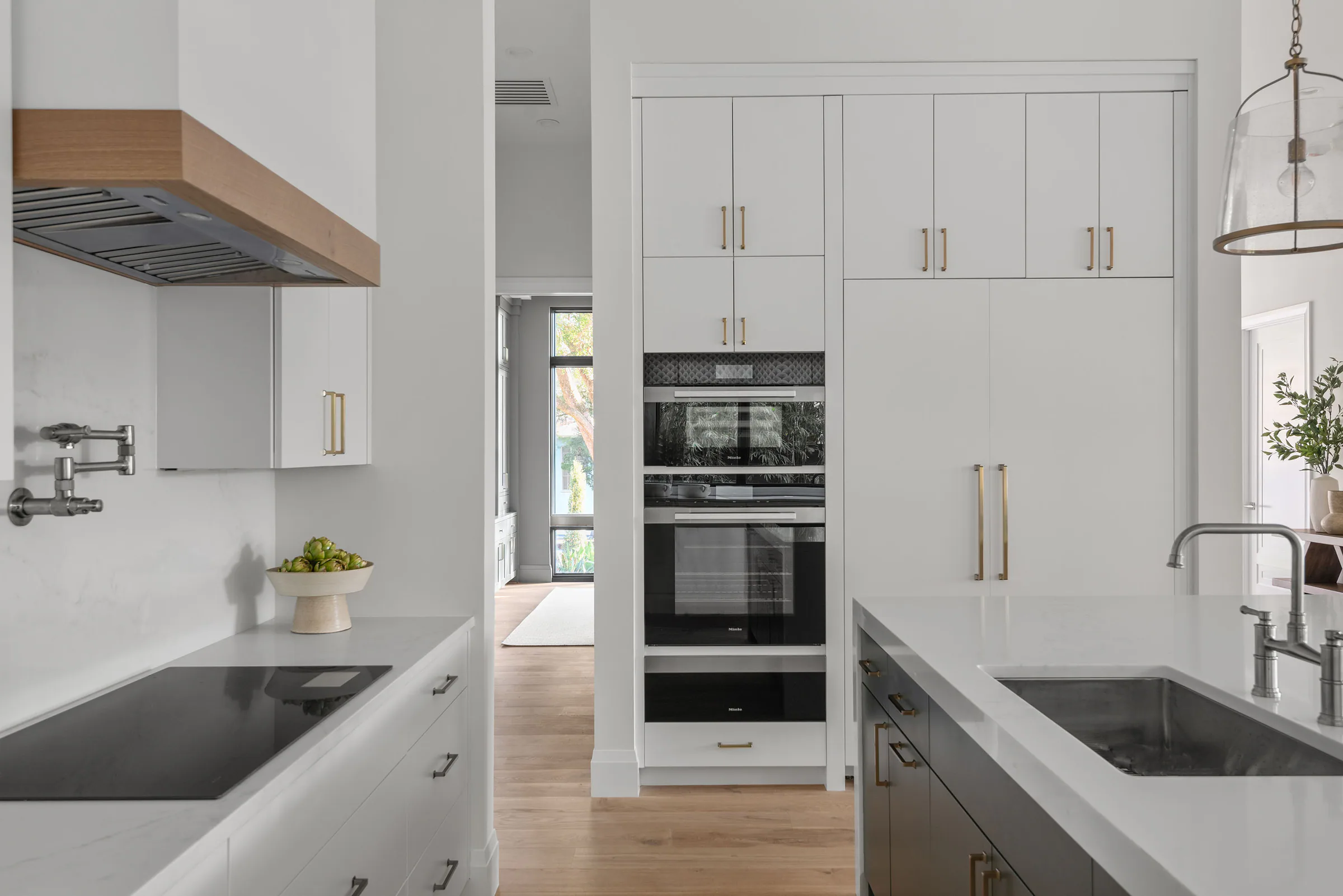 Kitchen island and cabinetry opening toward the dining and living spaces. Rockwood, a custom home by Rare Builders in Orlando.
