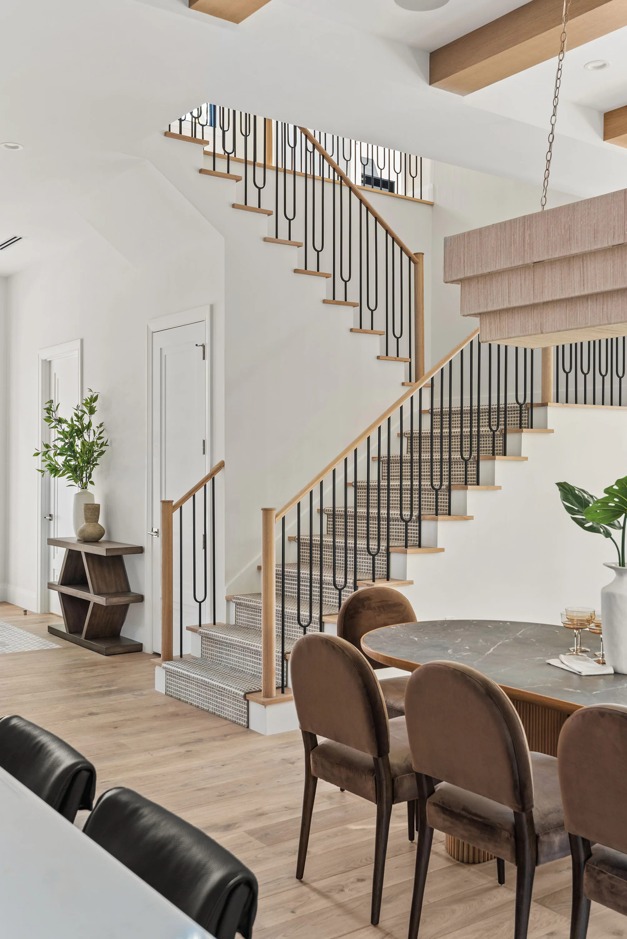 White kitchen cabinetry and integrated appliances beside the stair.