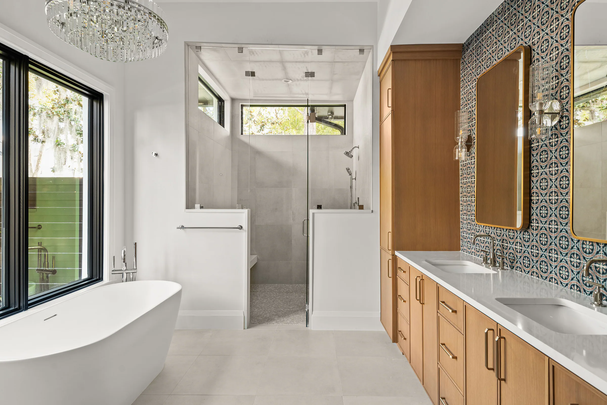 Bathroom with a freestanding tub, wood vanity and patterned wall tile. Rockwood, a custom home by Rare Builders in Orlando.