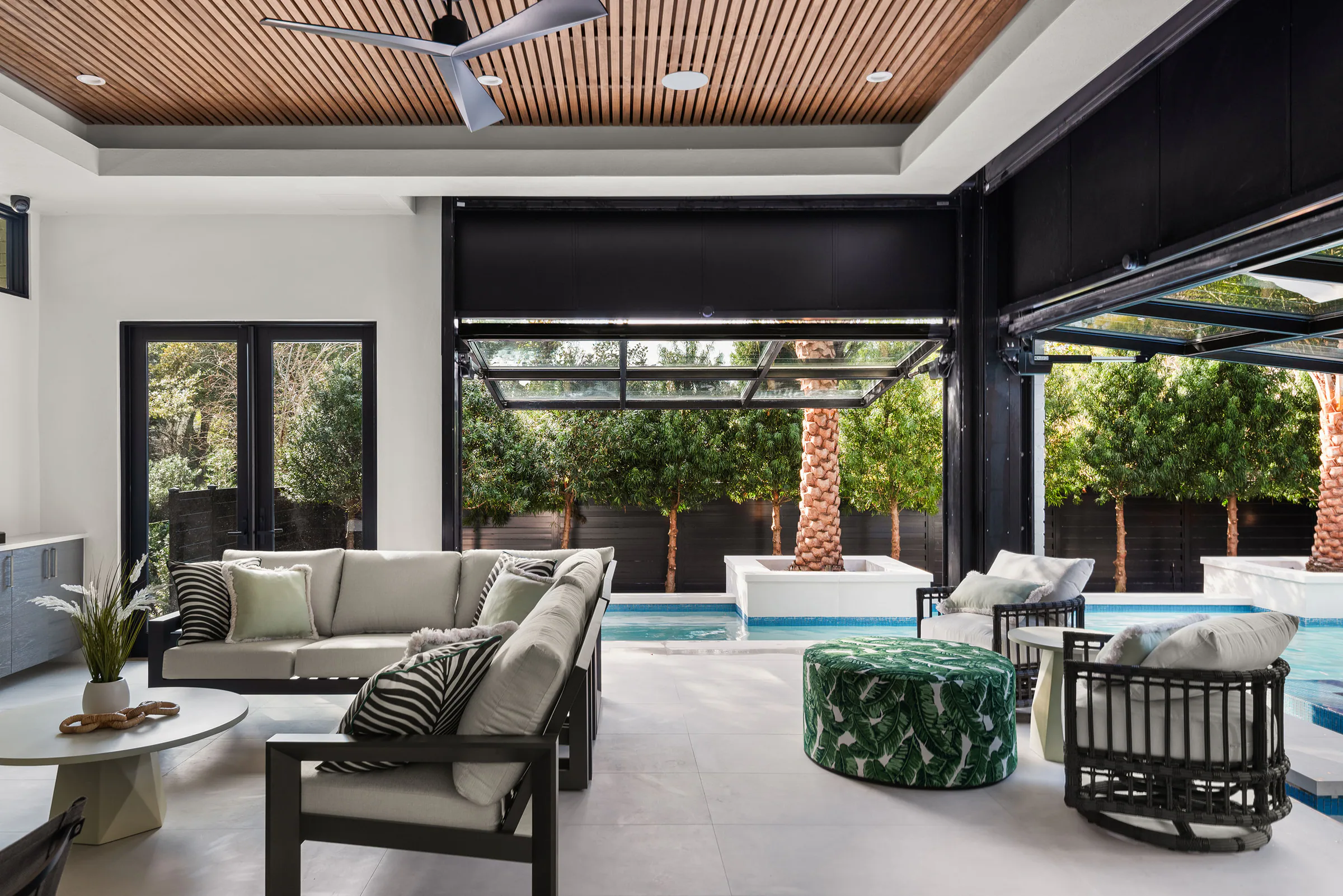 Covered outdoor room with a wood ceiling and retractable screens. Rockwood, a custom home by Rare Builders in Orlando.
