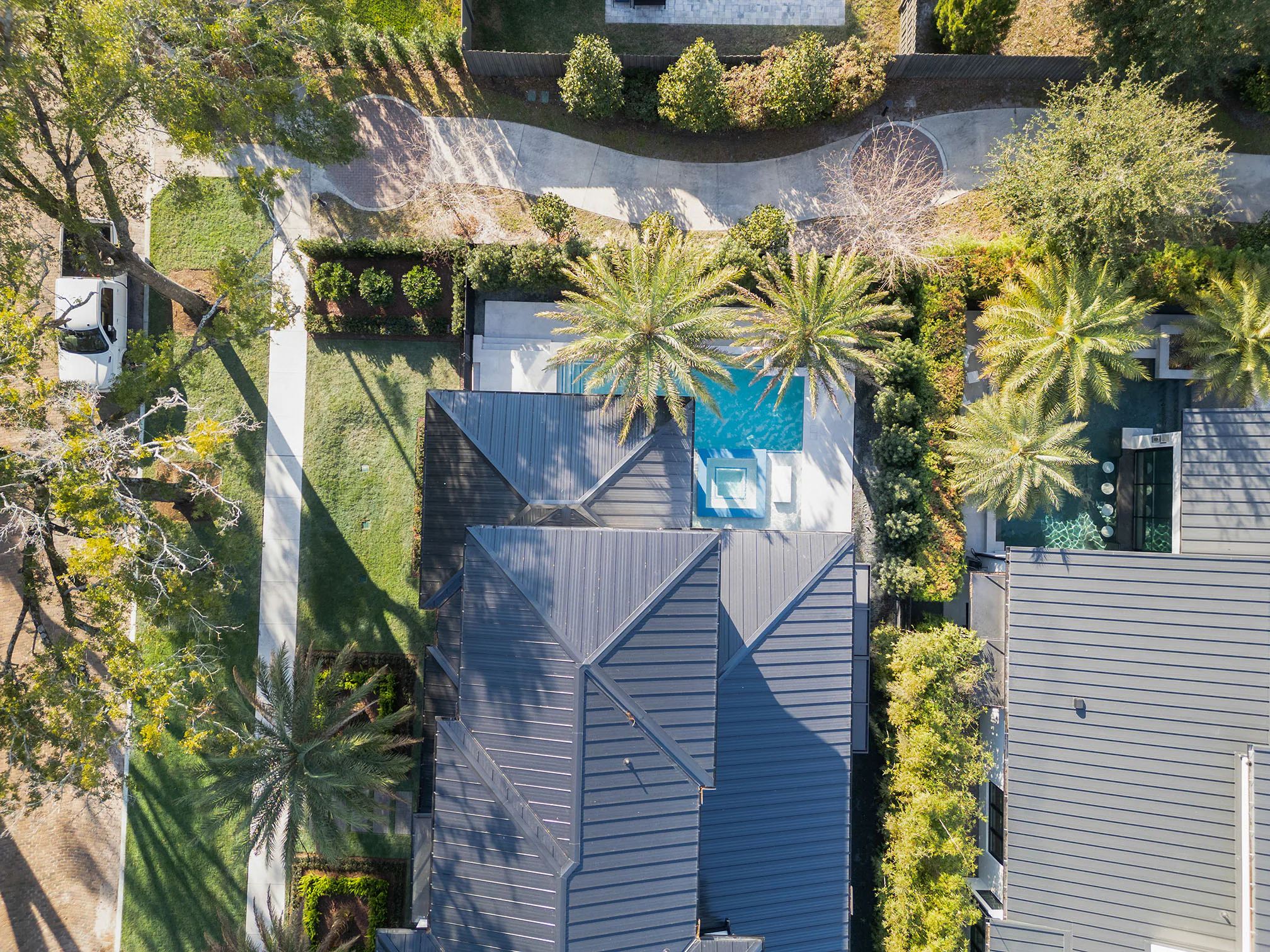 Aerial view of the residence, pool and surrounding tree canopy.