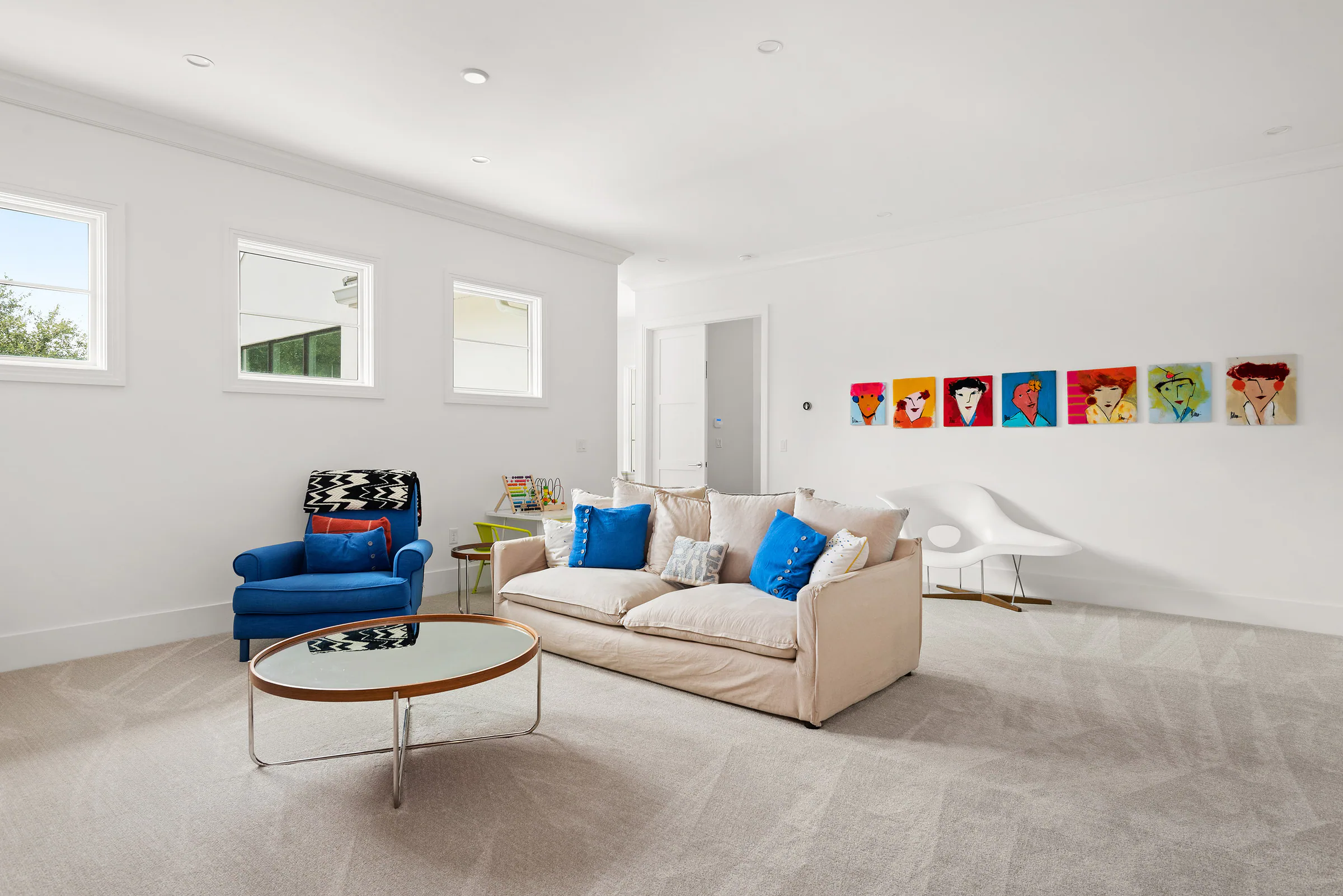 Bright playroom with low seating and colorful wall art. Killarney, a custom home by Rare Builders in Orlando.