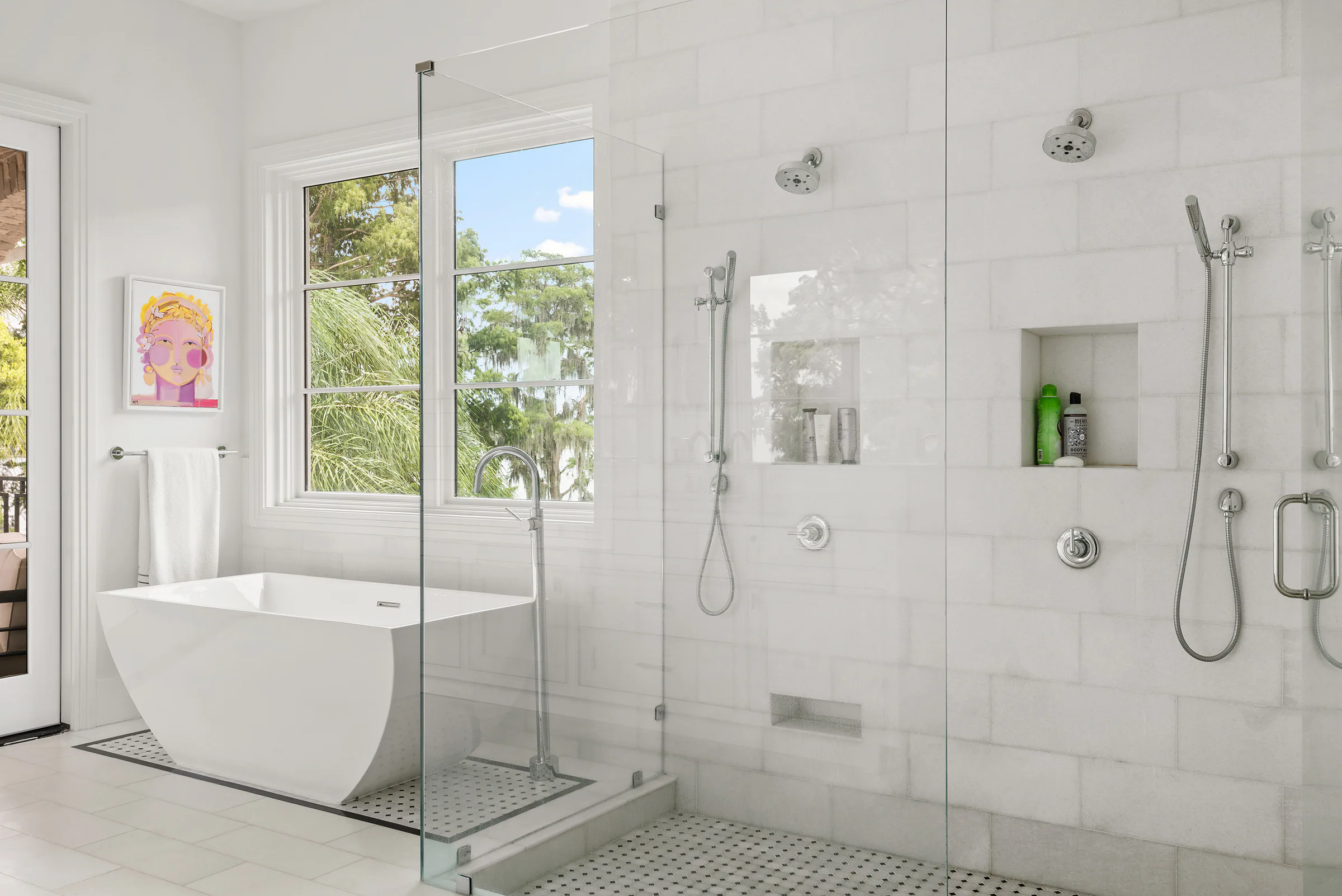Freestanding tub and glass shower in a pale tiled bathroom.