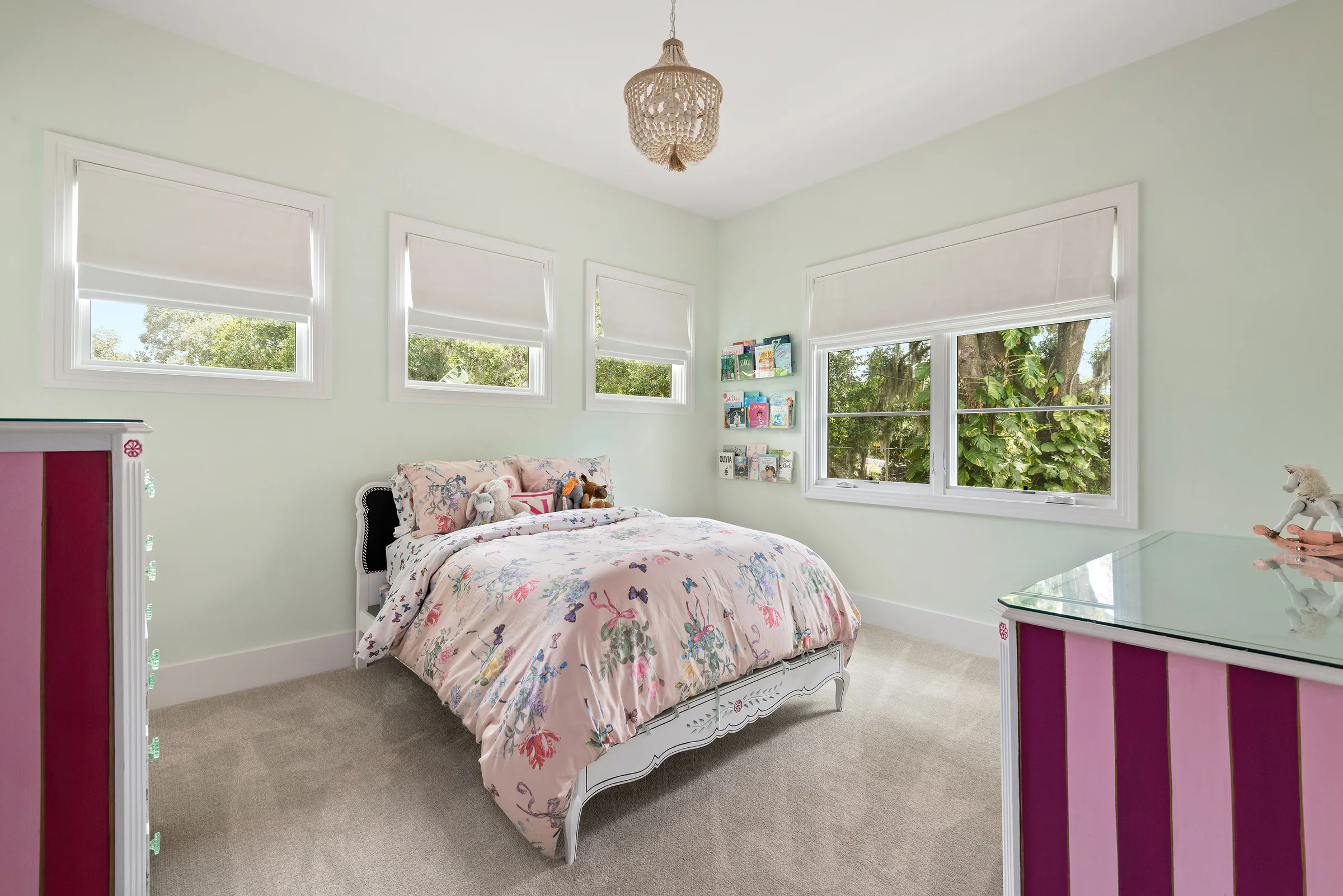 Bedroom with patterned bedding and windows on two sides.