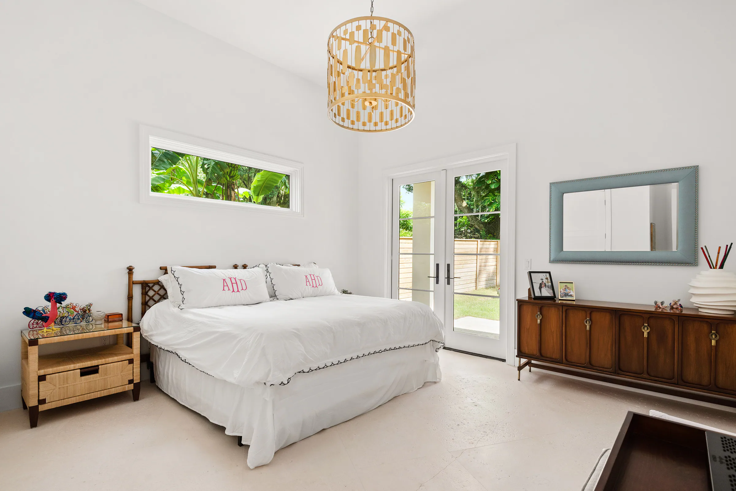 Guest bedroom with a pale bed and dark wood dresser.