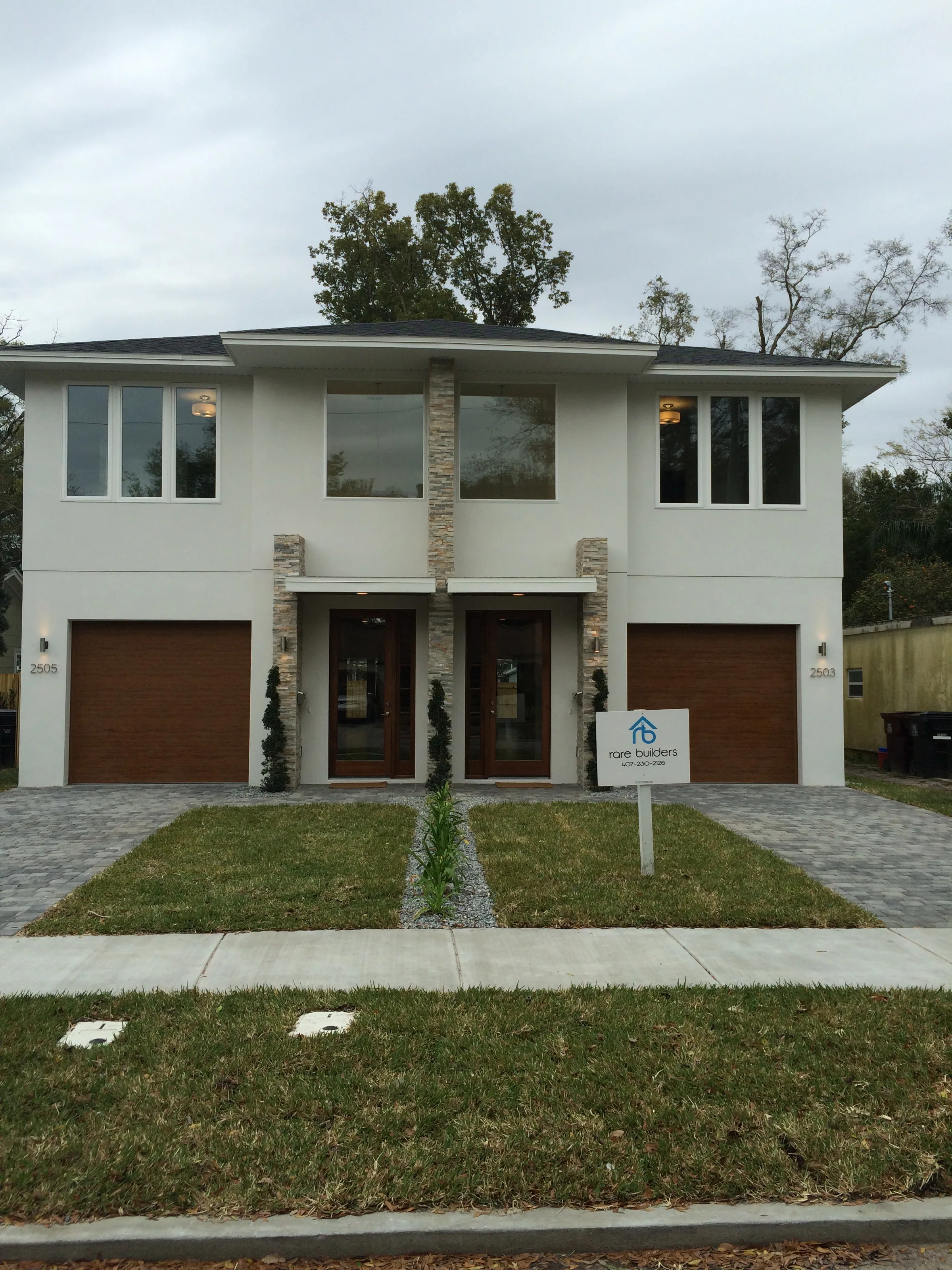 Two-story Depauw duplex with paired entries, separate garages and stone accents.
