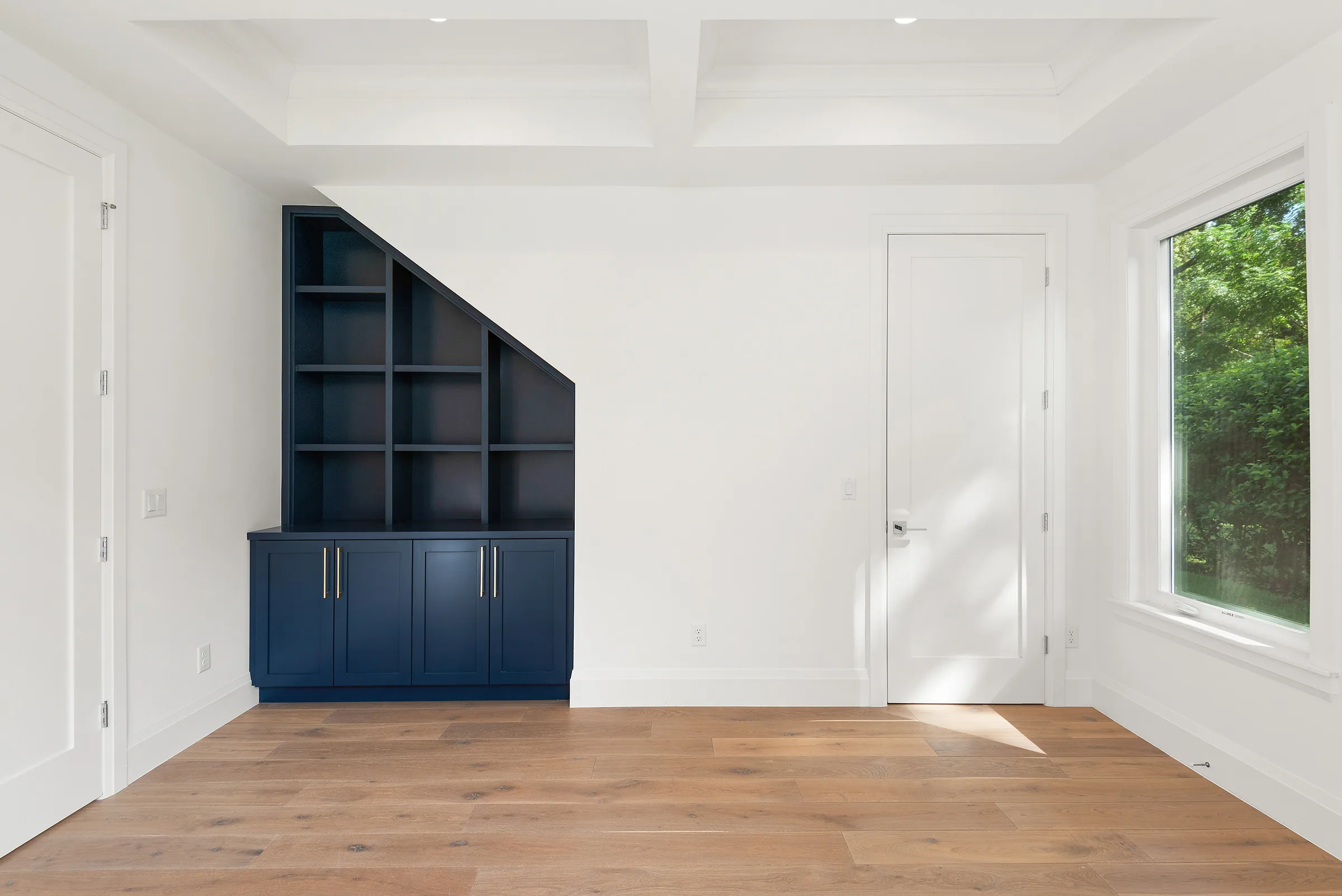 Blue built-in cabinets and open shelves with an angled top beneath a geometric ceiling.
