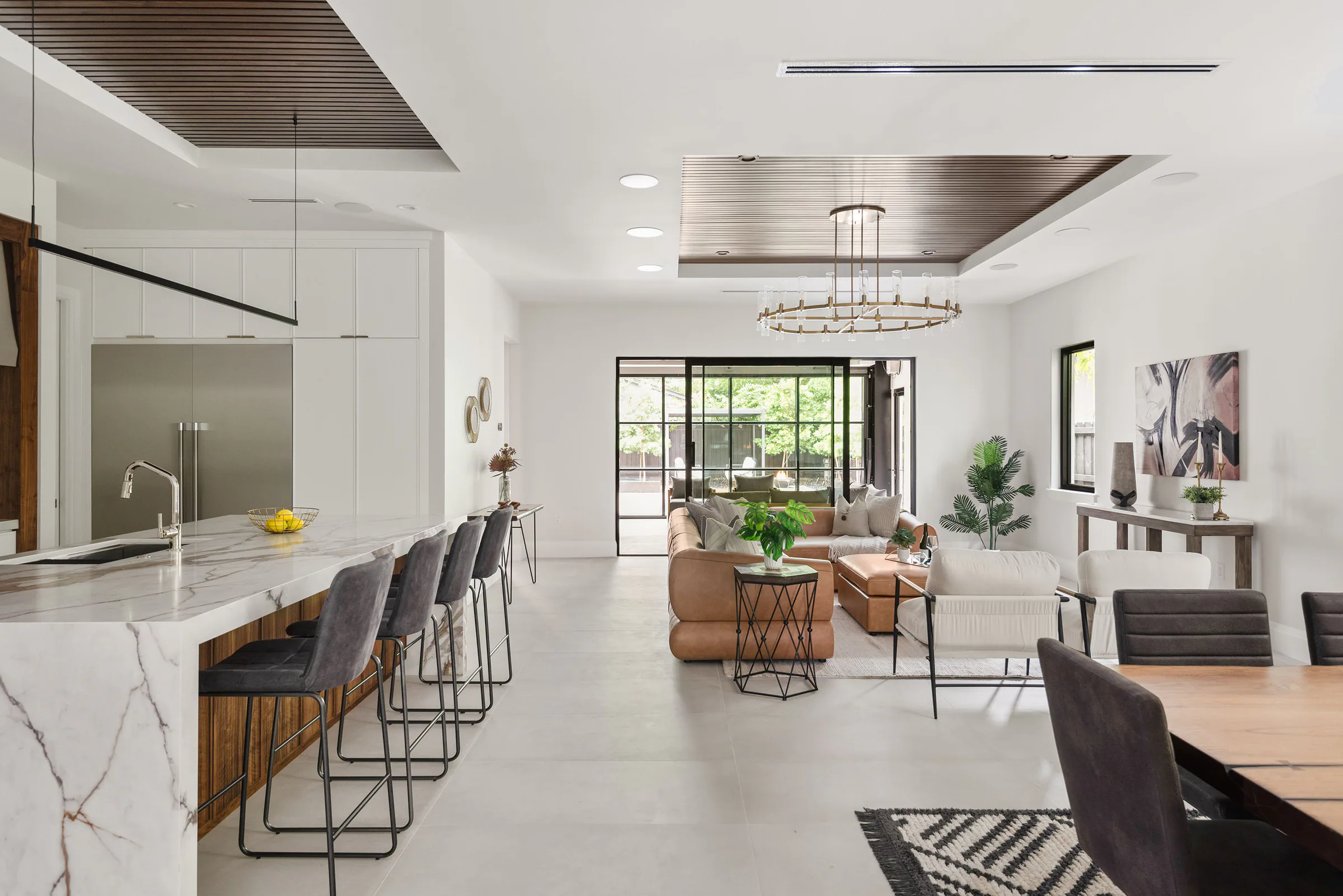 Open kitchen and dining area beneath dark wood ceiling insets.