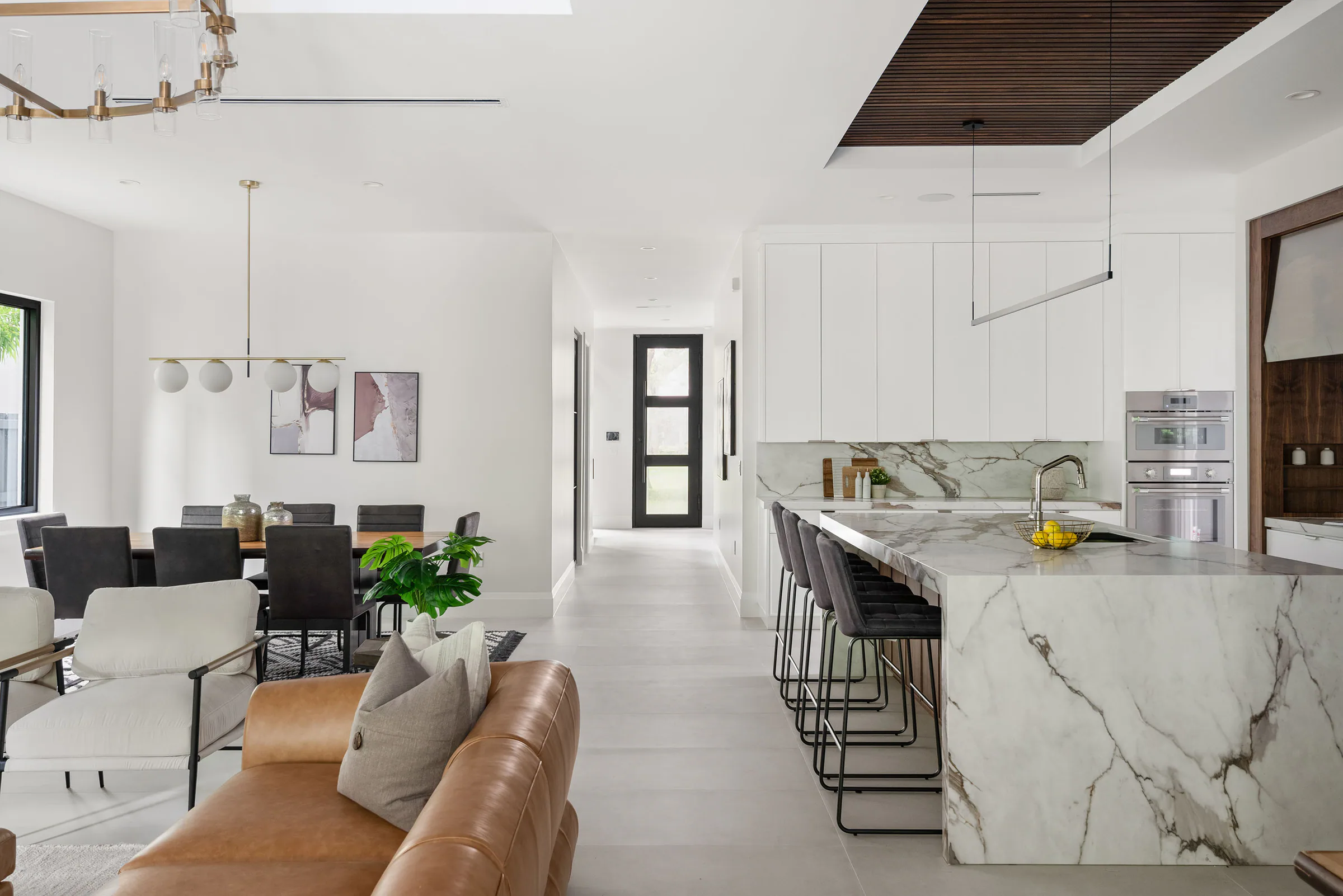 Dining table and pale seating beside the open kitchen.